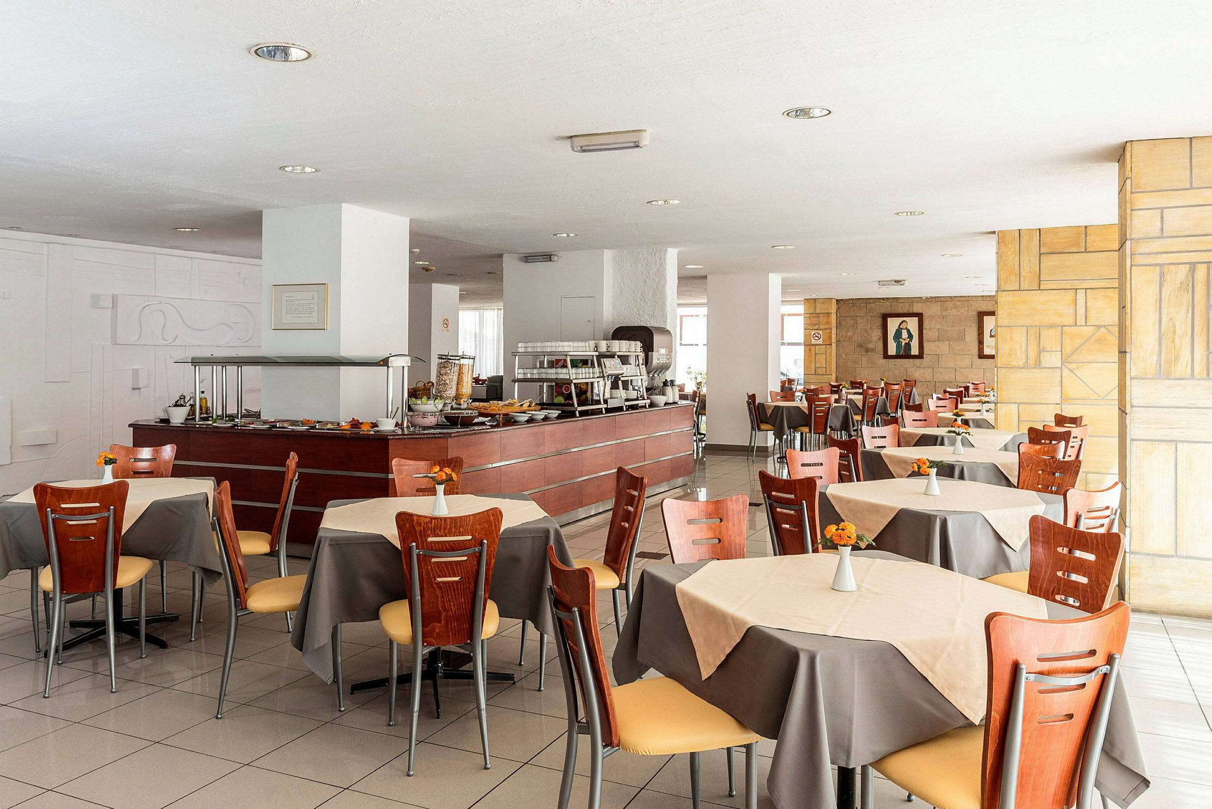 Restaurangens matsal med bord, stolar och en buffédisk. (AI-genererad text)