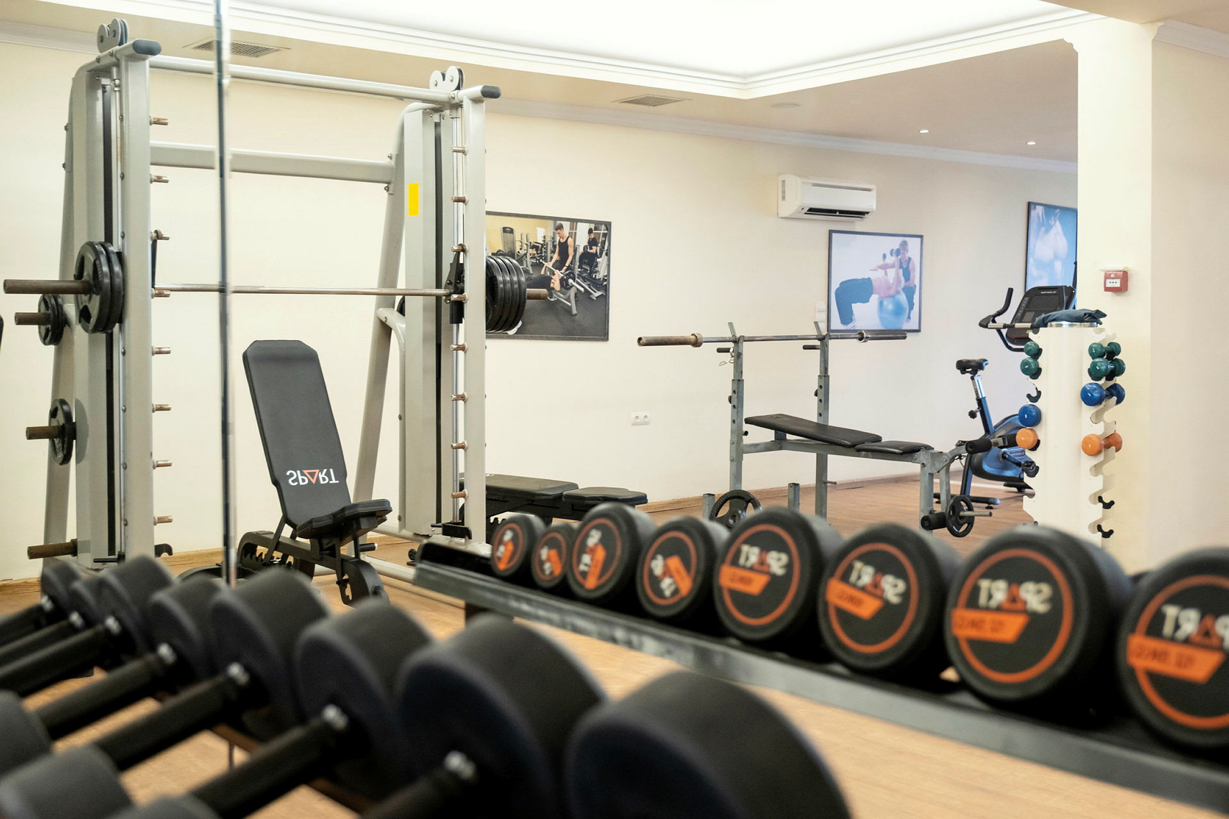 Ett gym med träningsmaskiner, bänkpress och hantlar. (AI-genererad text)