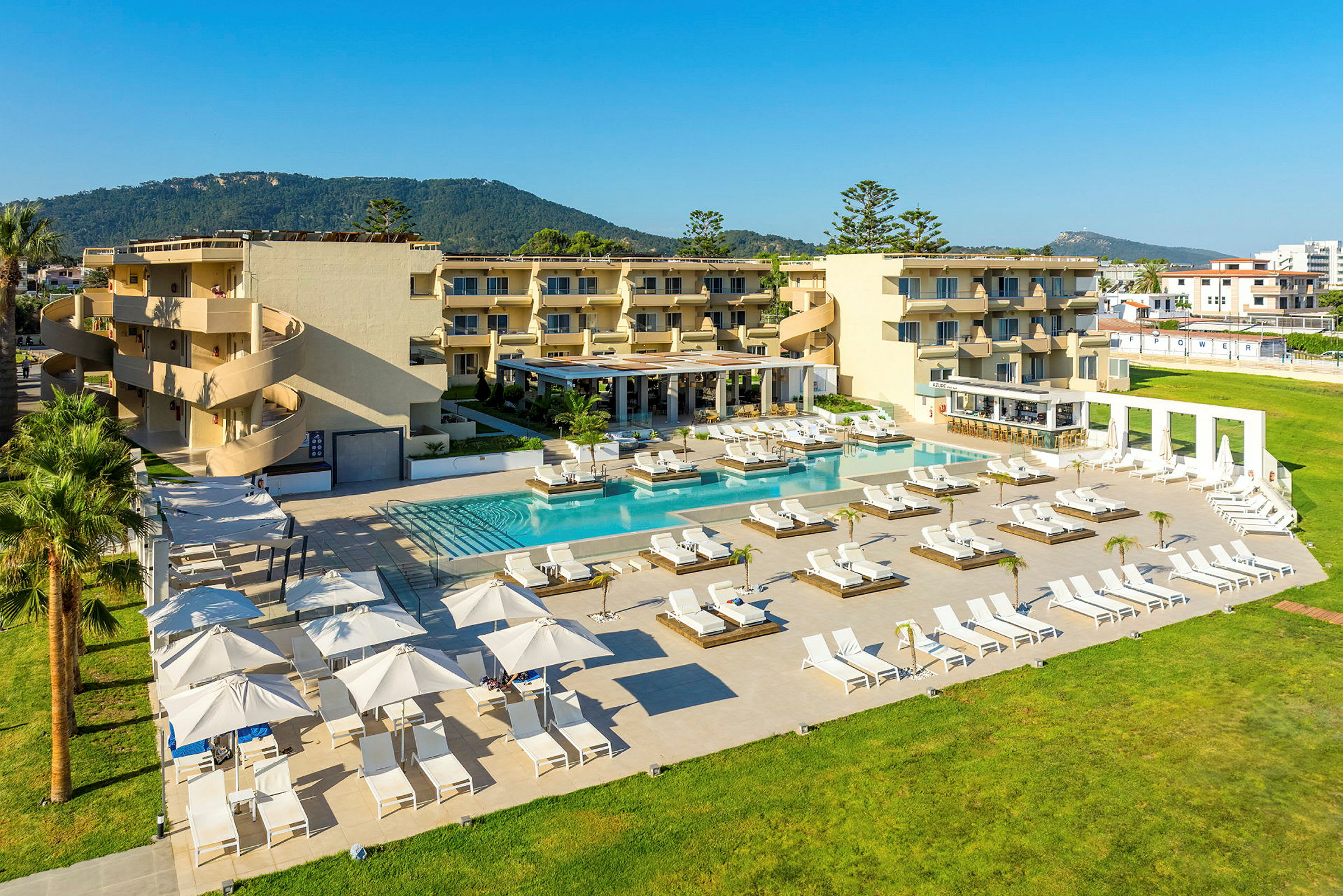 Hotellanläggning med pool och solstolar. (AI-genererad text)
