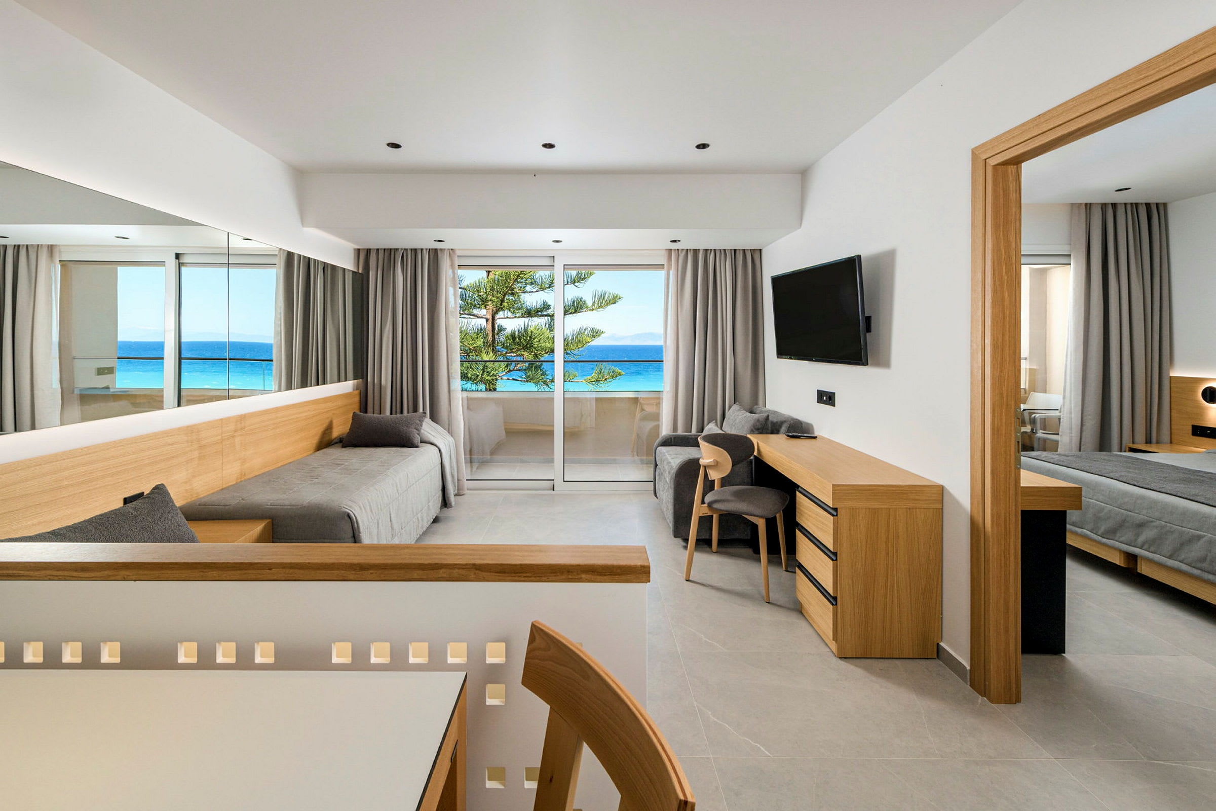 Ett modernt hotellrum med skandinavisk inredning och utsikt över havet från balkongen. (AI-genererad text)