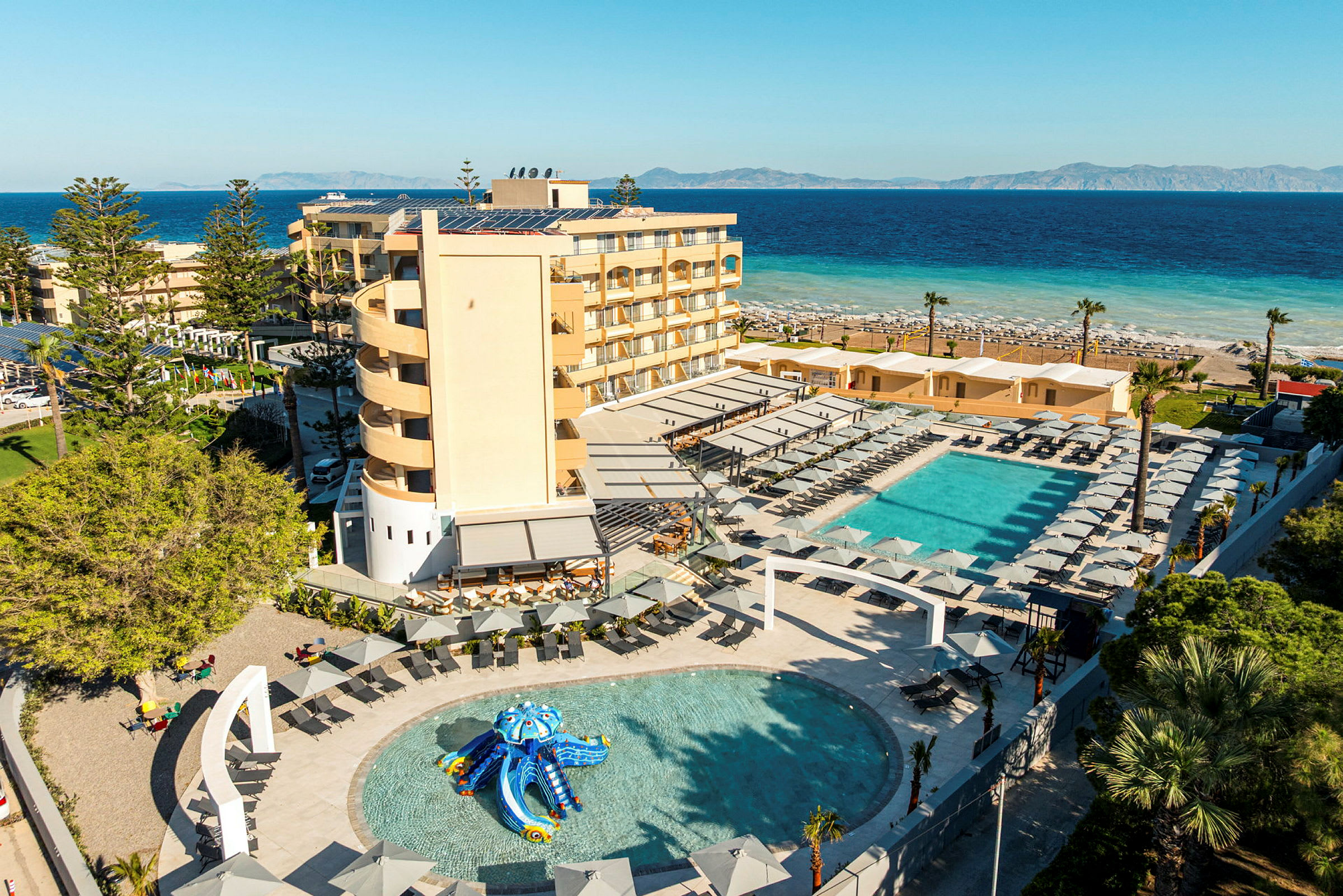 En strandnära resort med pool, solstolar och gröna omgivningar. (AI-genererad text)