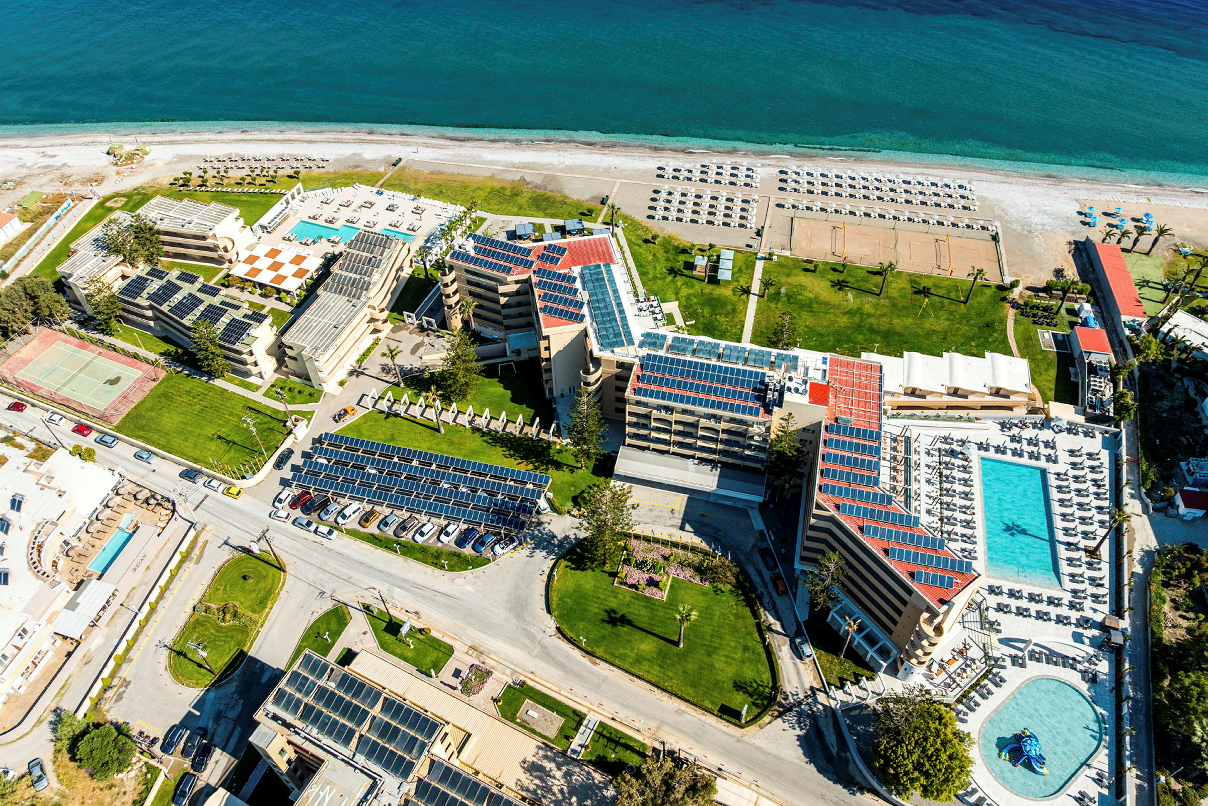 Hotellkomplex med pooler och solstolar, nära havet. (AI-genererad text)