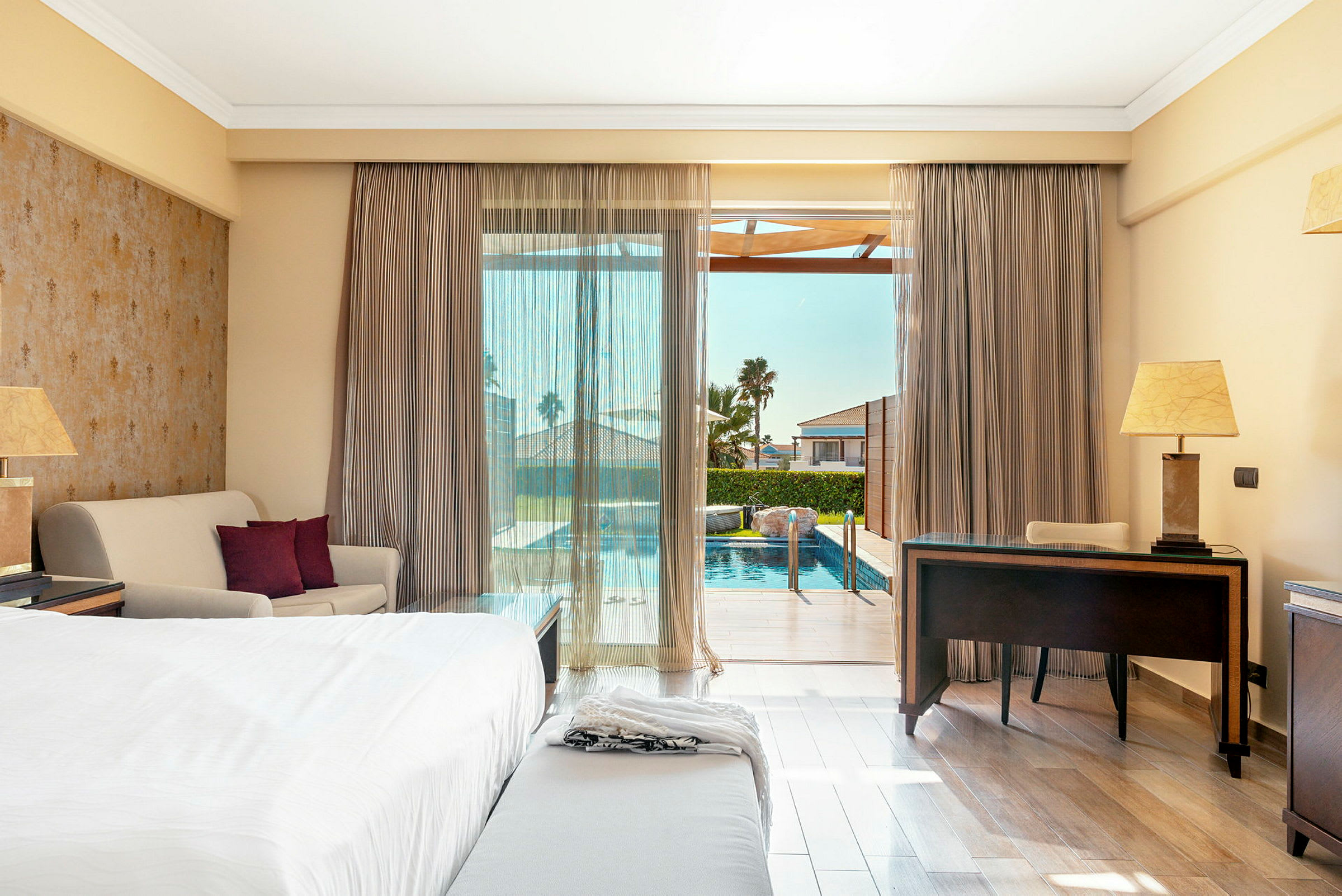 Ett hotellrum med utsikt över en pool utanför. (AI-genererad text)