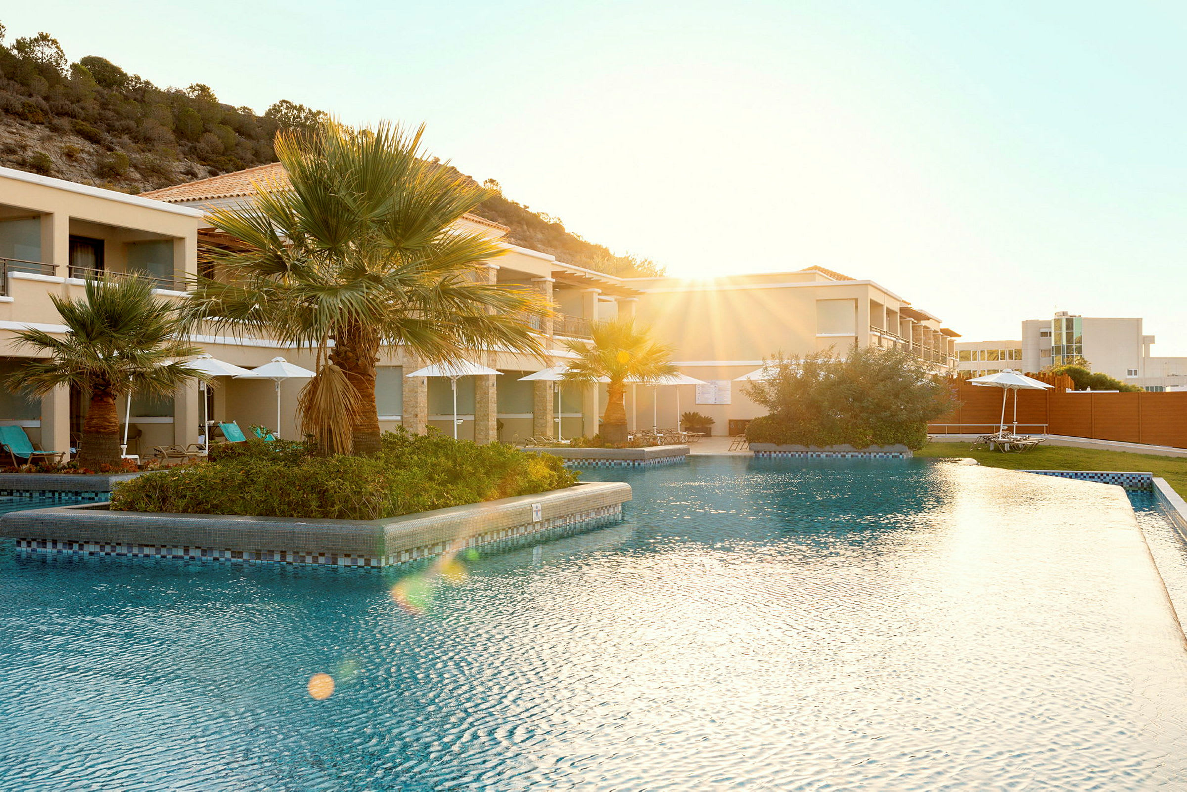 Utomhuspool vid en resort med palmer i bakgrunden. (AI-genererad text)