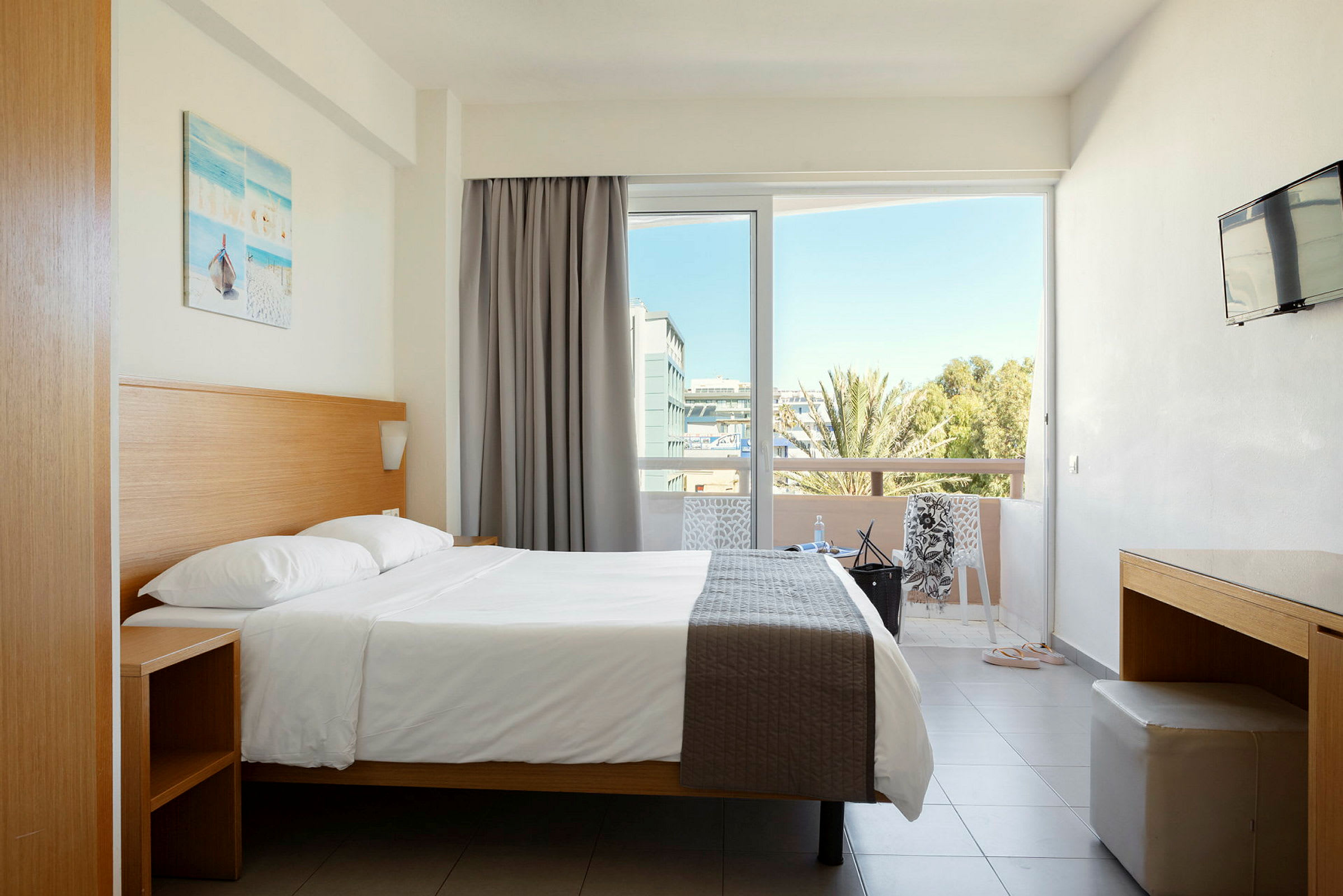 Hotellrum med dubbelsäng, balkong och utsikt. (AI-genererad text)
