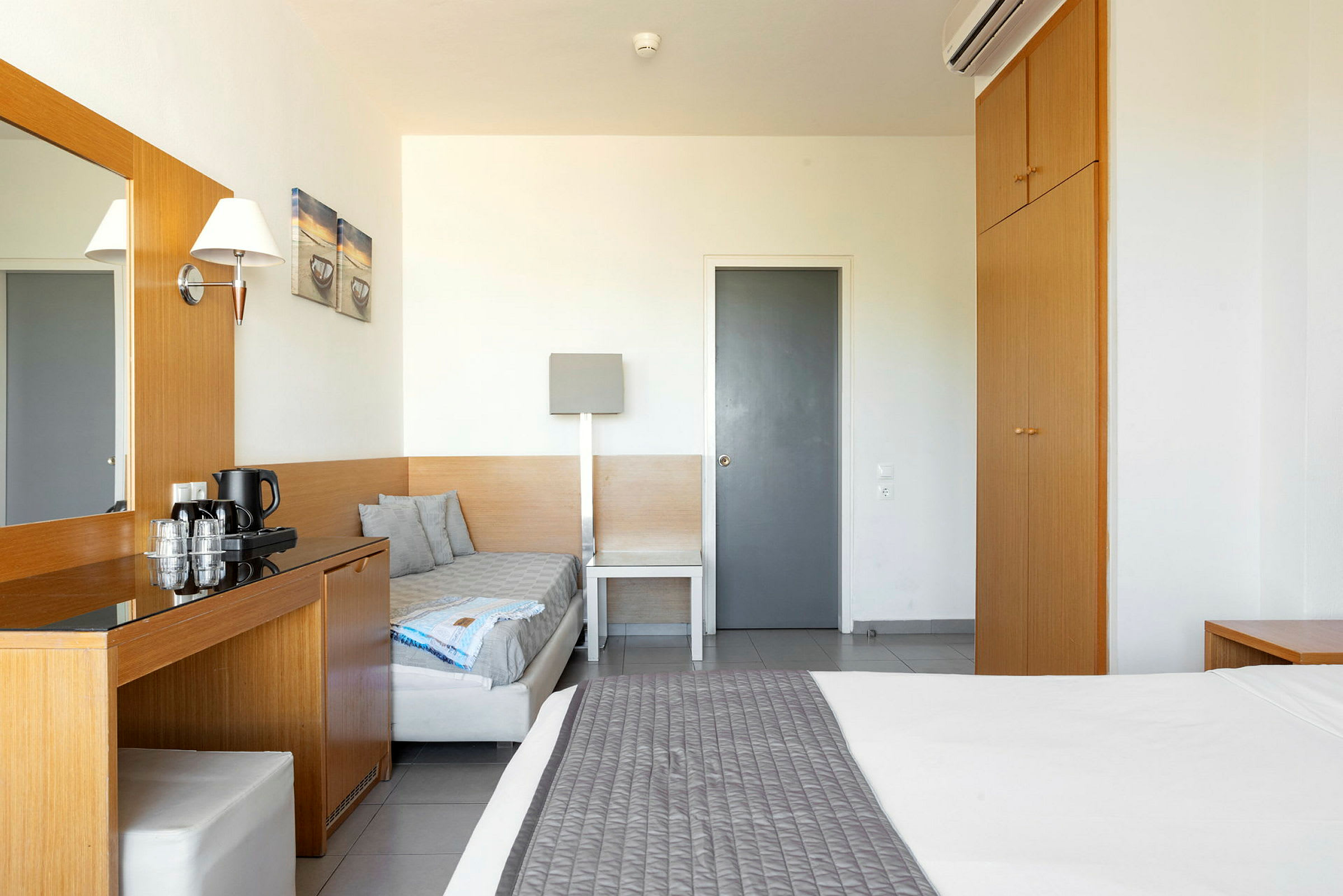 Ett hotellrum med säng, garderob och skrivbord. (AI-genererad text)