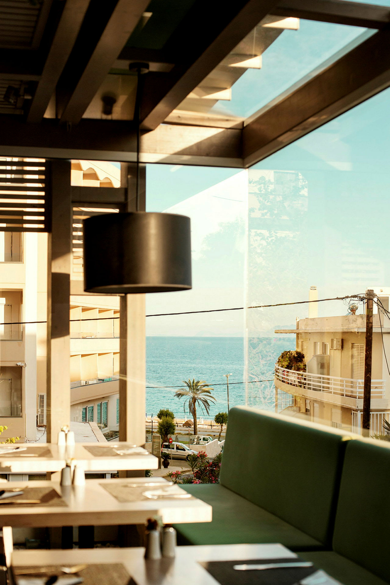 Utsikt från restaurang med sittplatser inomhus och havet i bakgrunden. (AI-genererad text)