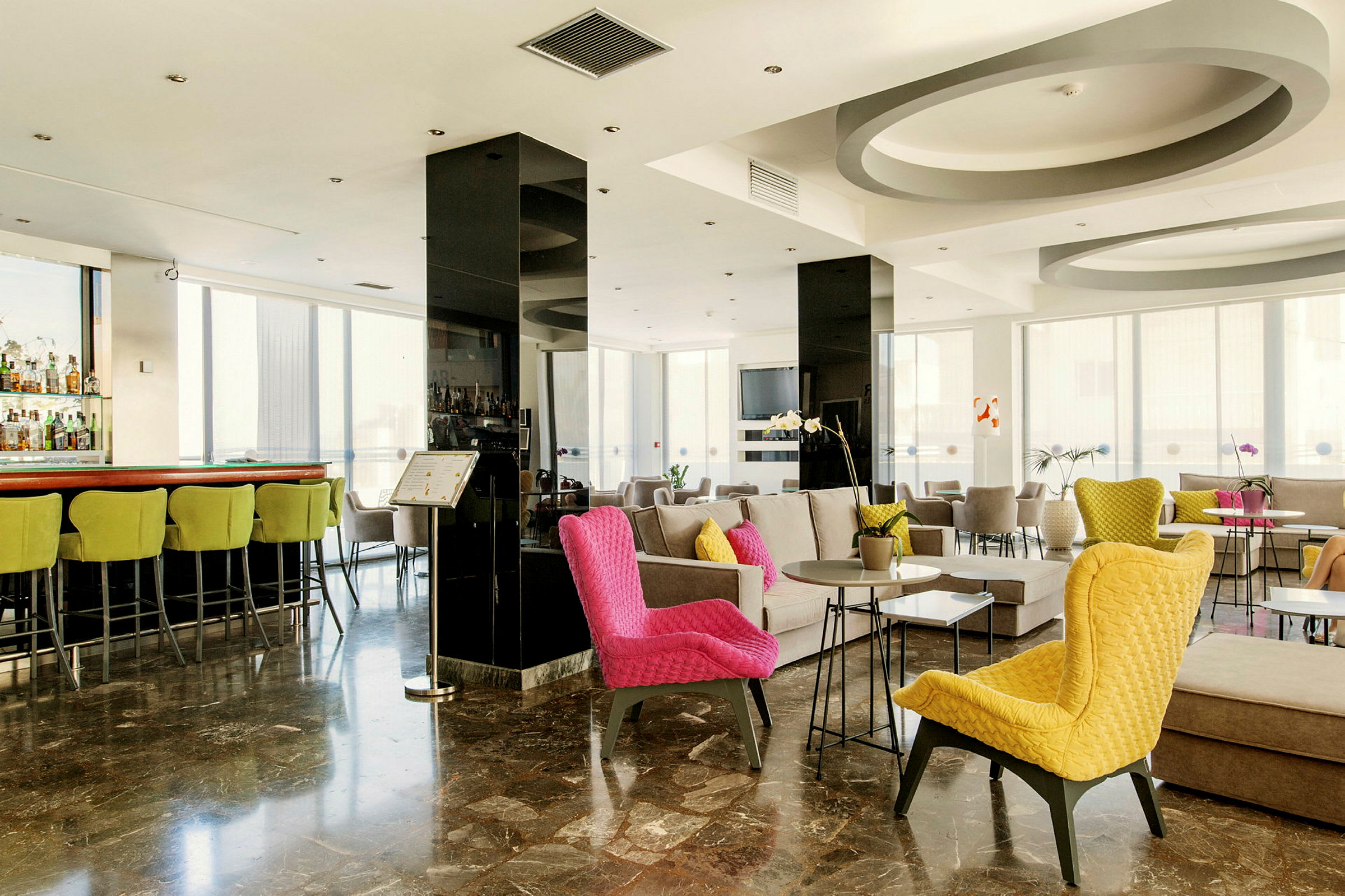 Interiören av en modern hotellobby med färgglada stolar och sittgrupper. (AI-genererad text)