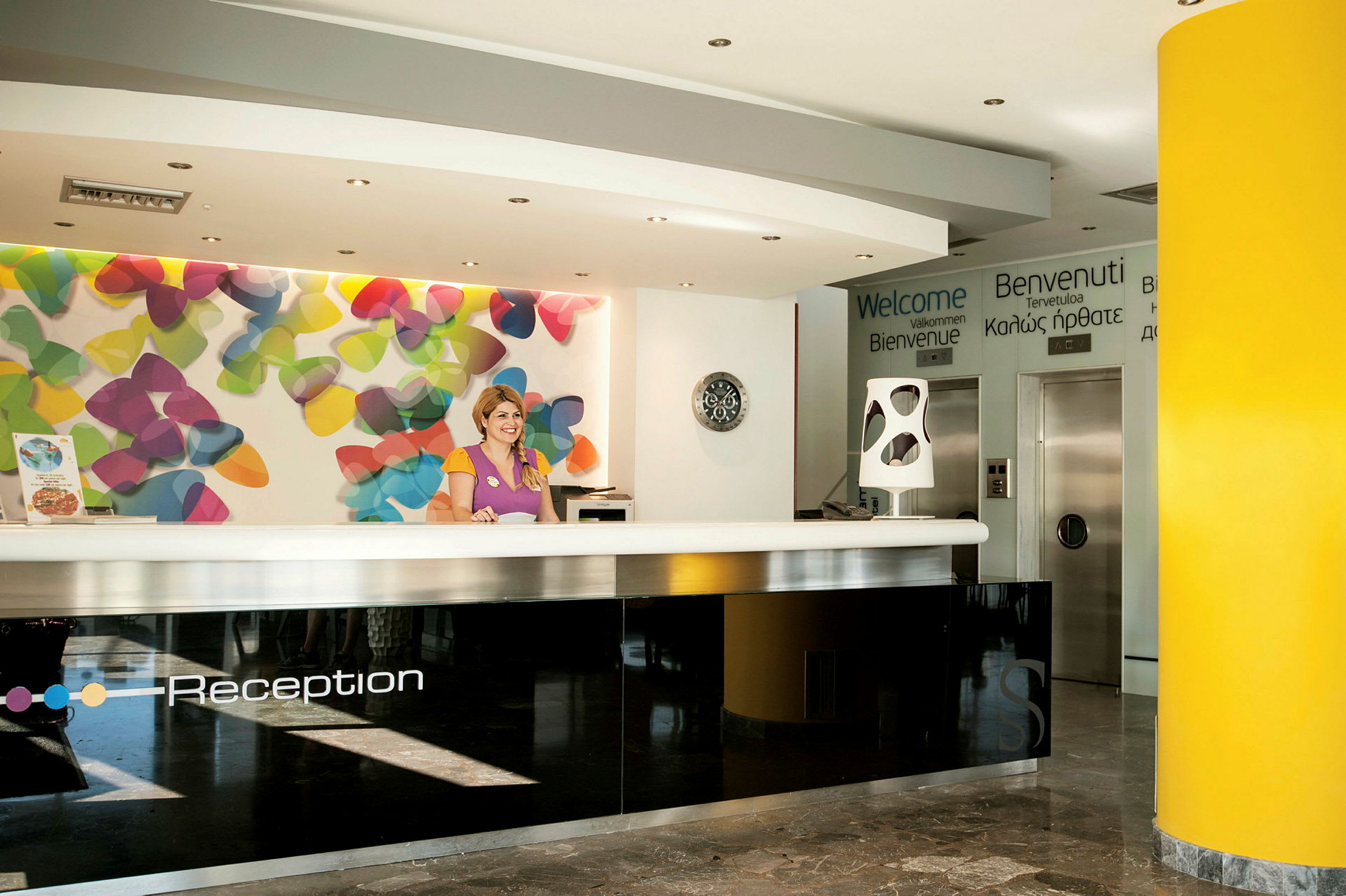 Reception med färgglad bakgrund och välkomstskyltar. (AI-genererad text)