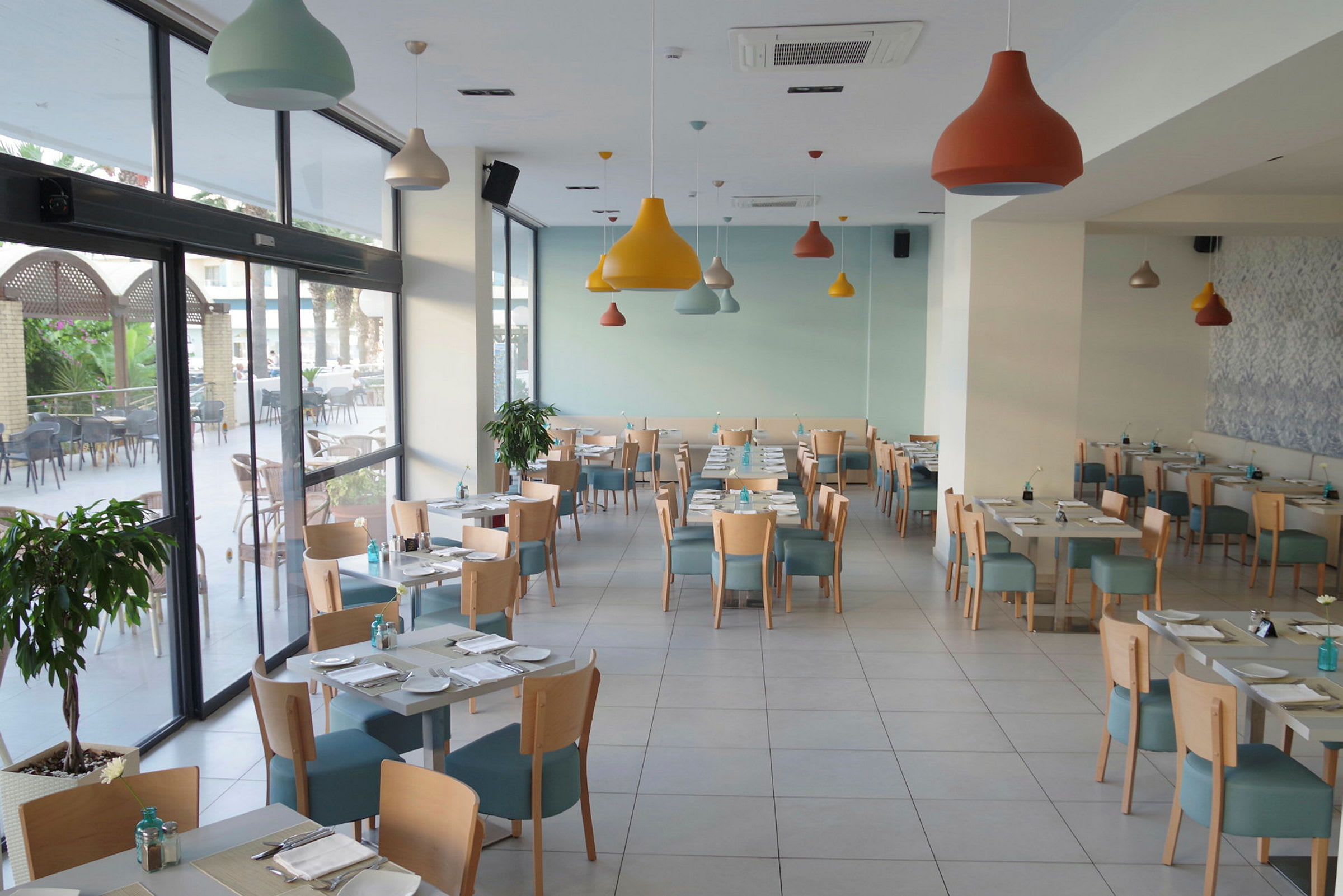 En ljus och modern restaurang med bord och stolar placerade. (AI-genererad text)