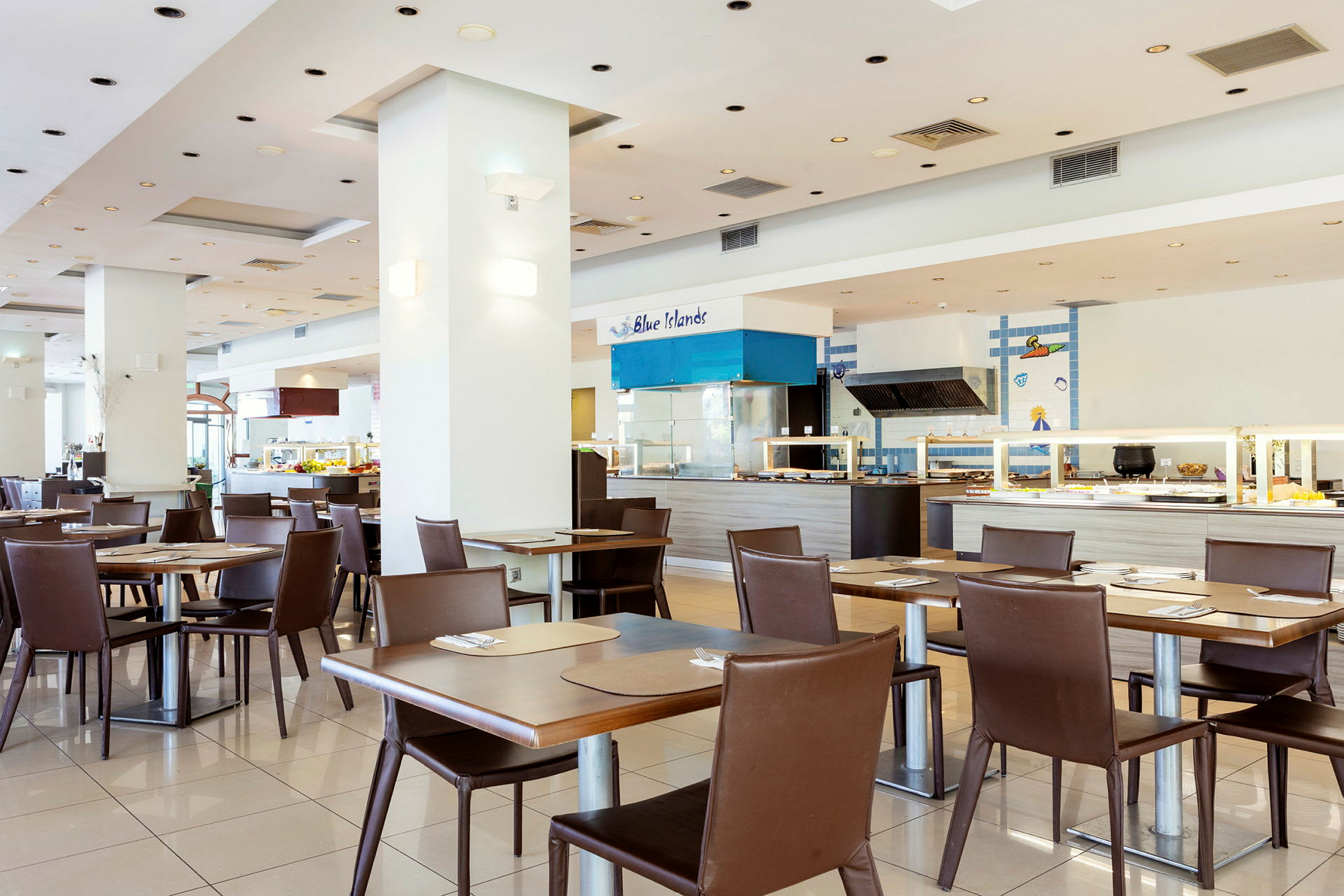 Restaurang med moderna bord och stolar samt en serveringsyta i bakgrunden. (AI-genererad text)