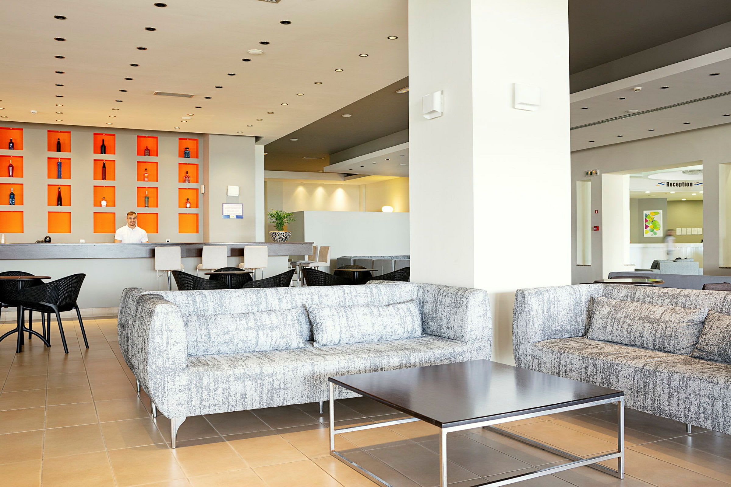 Luftigt hotellobbyområde med soffgrupper och receptionsdisk. (AI-genererad text)