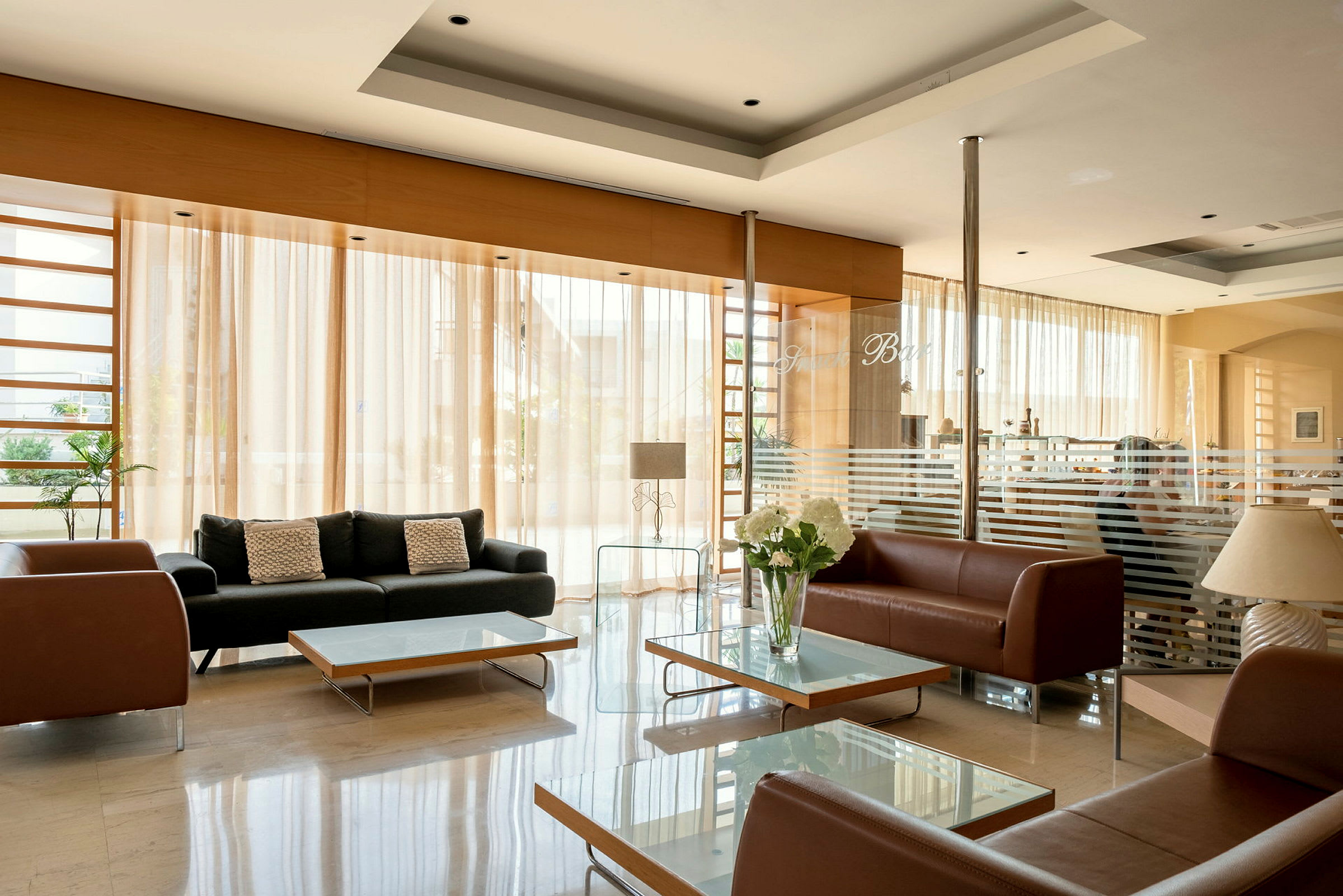 Hotellobby med soffor och glasbord. (AI-genererad text)