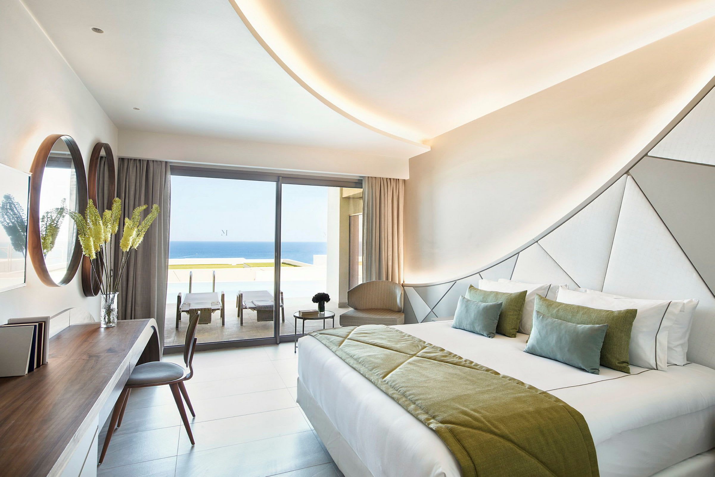 Modern hotellrum med dubbelsäng och utsikt över havet genom stora fönster. (AI-genererad text)