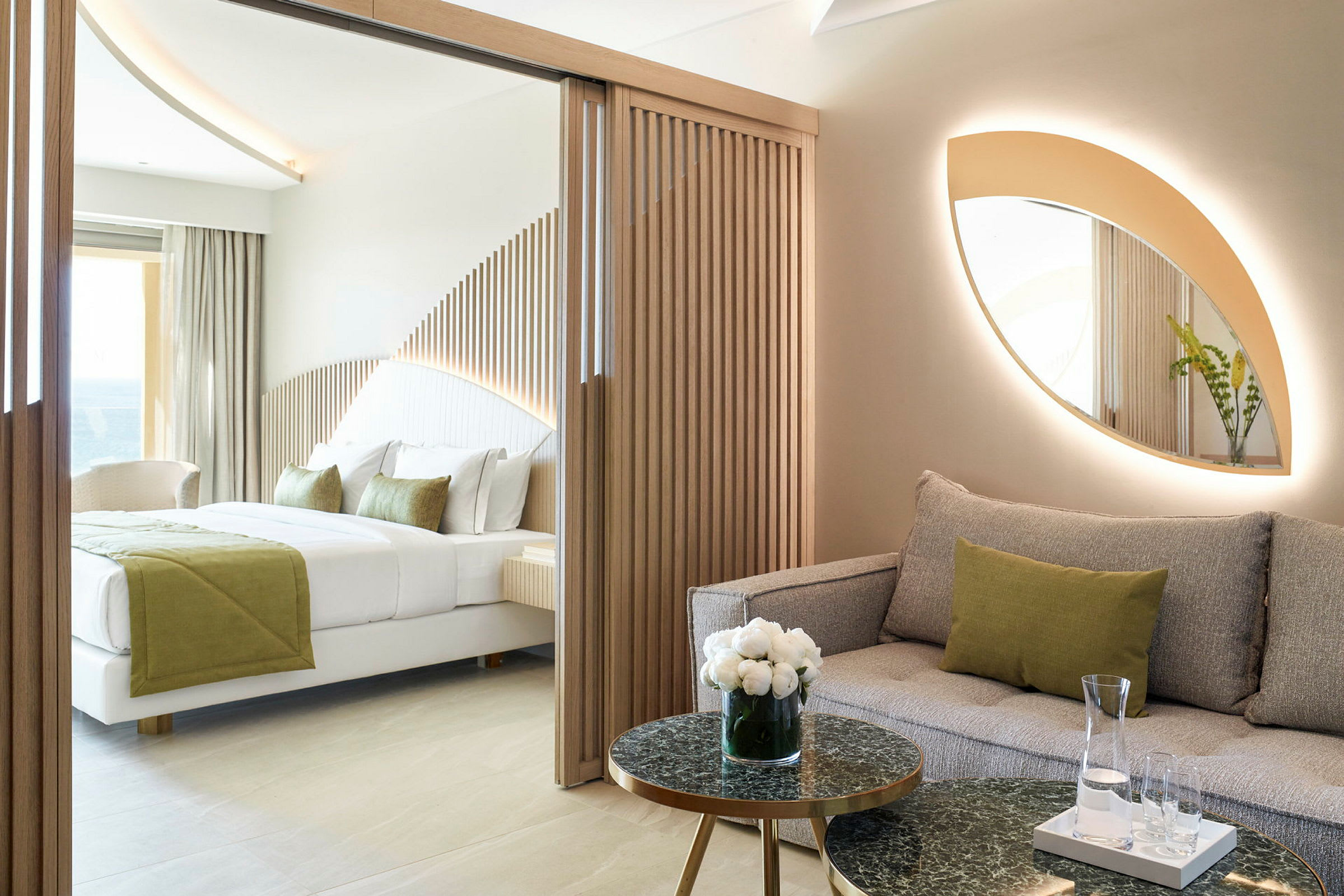 Modernt hotellrum med soffa och säng, inrett med naturliga färger och trädetaljer. (AI-genererad text)