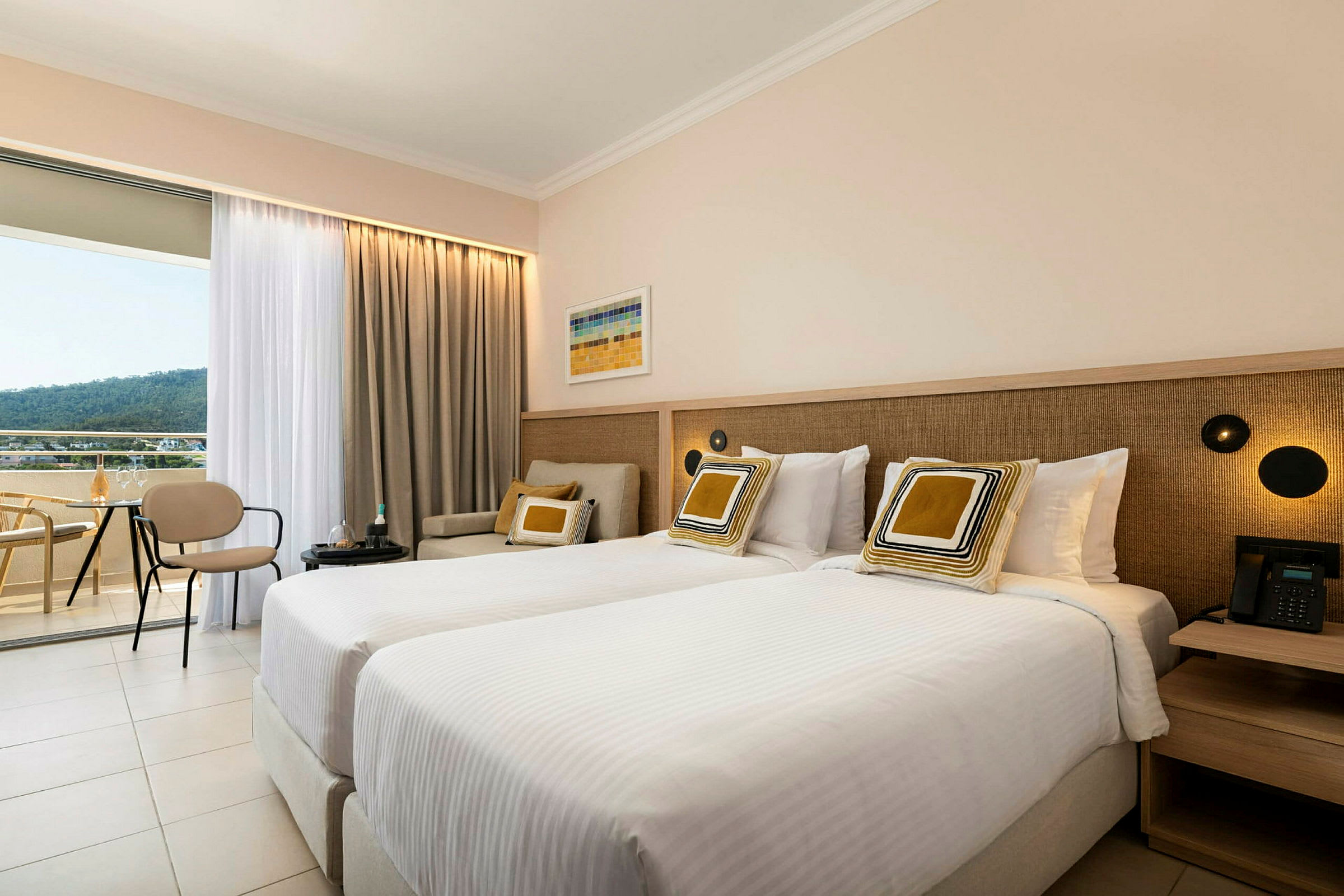 Två sängar i ett hotellrum med sittmöbler och en uteplats. (AI-genererad text)