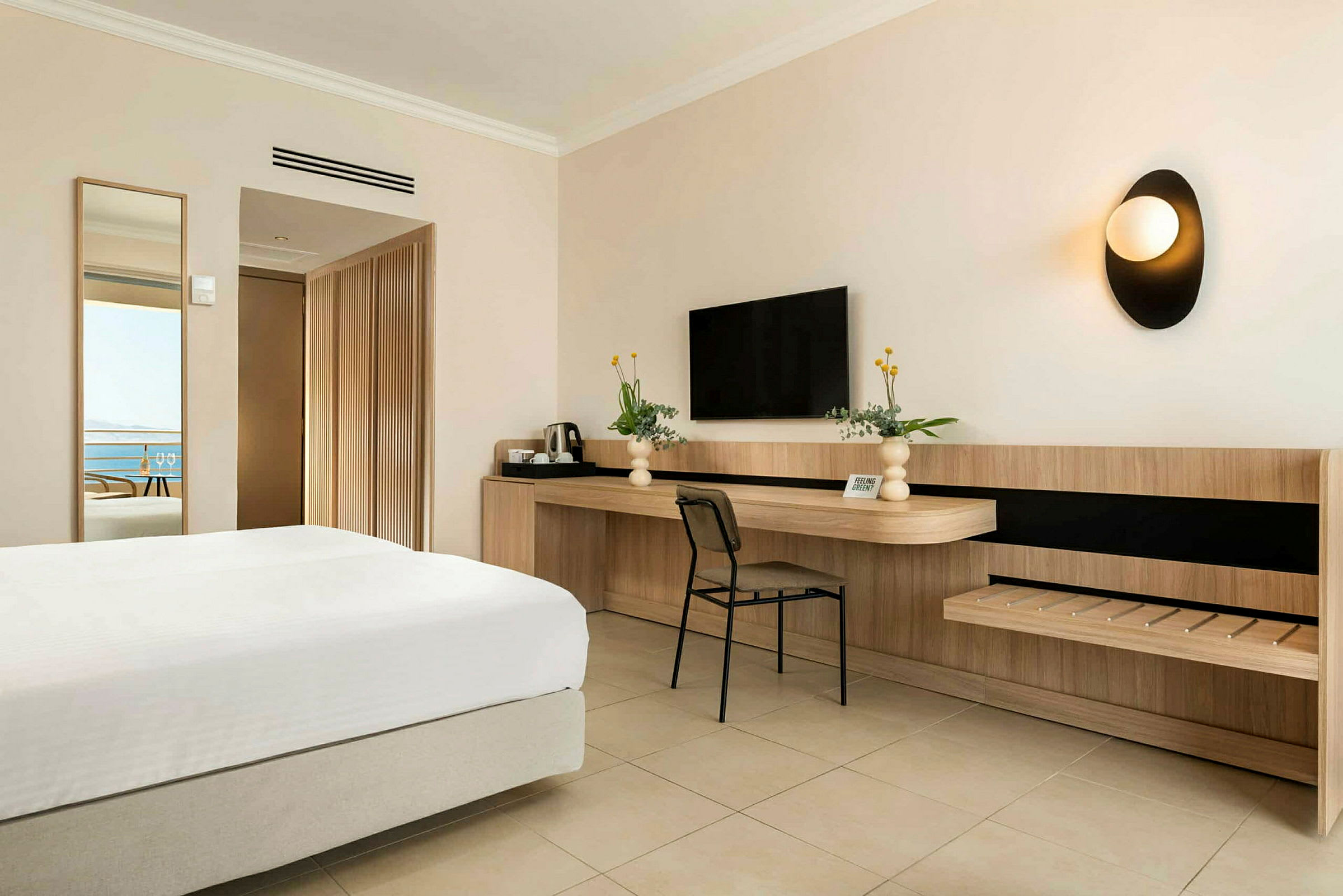 Hotellrum med säng, skrivbord och TV. (AI-genererad text)