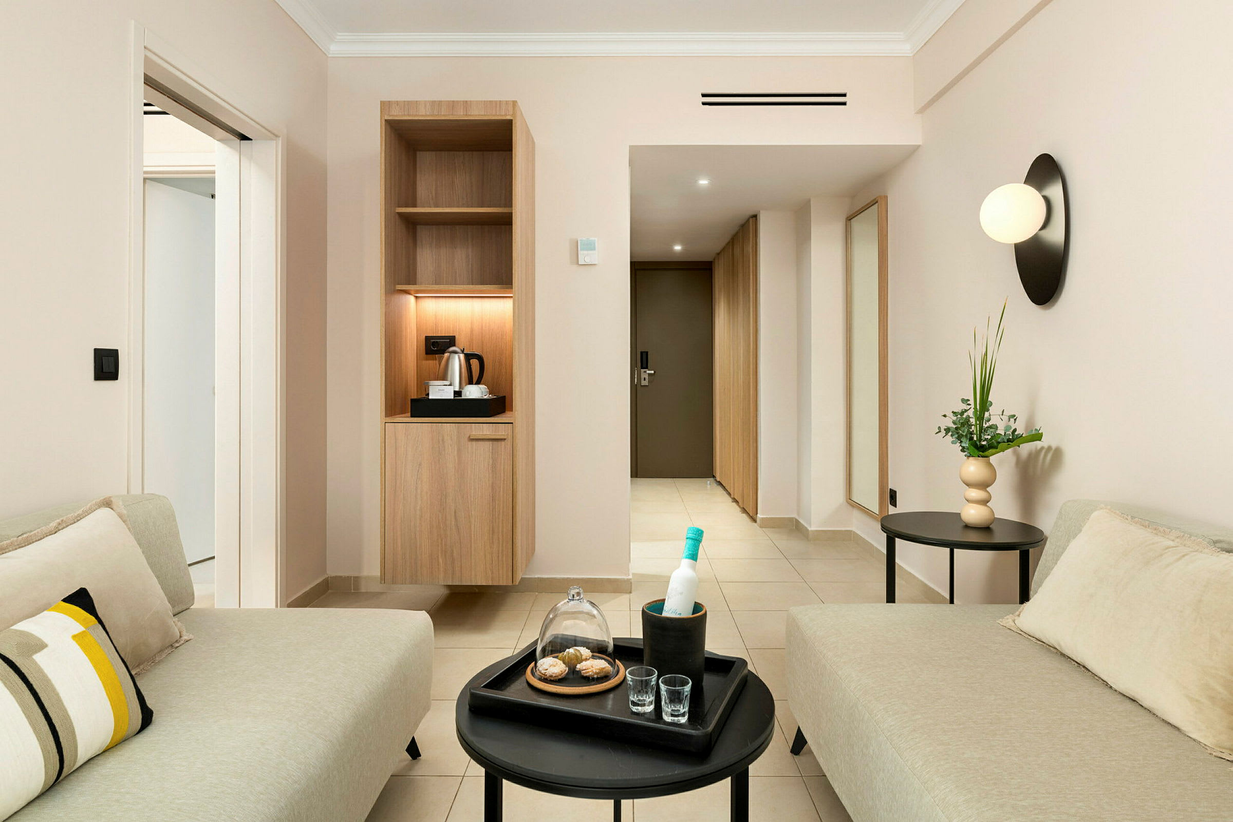 Ett modernt hotellrum med sittgrupp och kaffebryggare. (AI-genererad text)