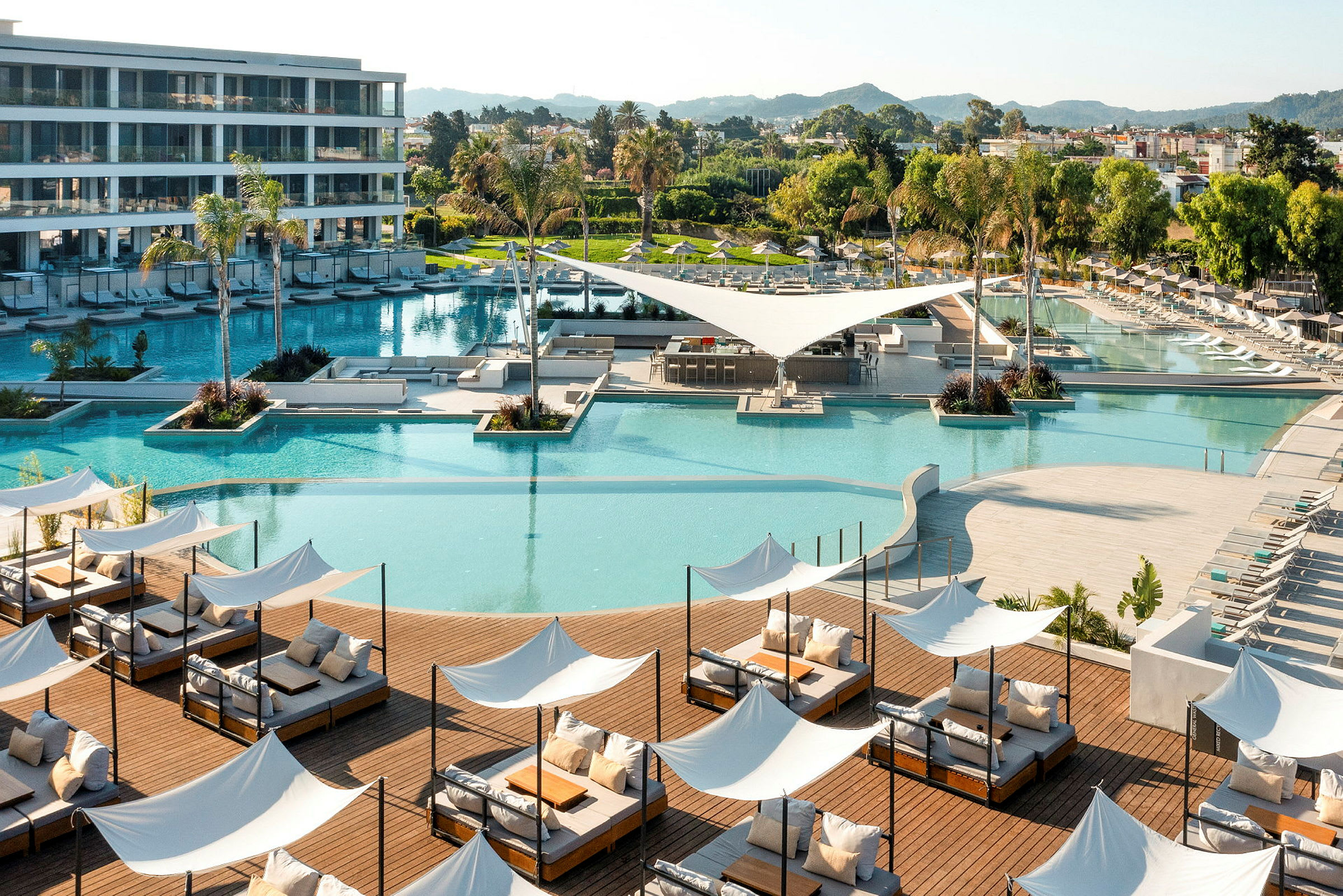 En modern semesterort med swimmingpool, solstolar och grönområden. (AI-genererad text)