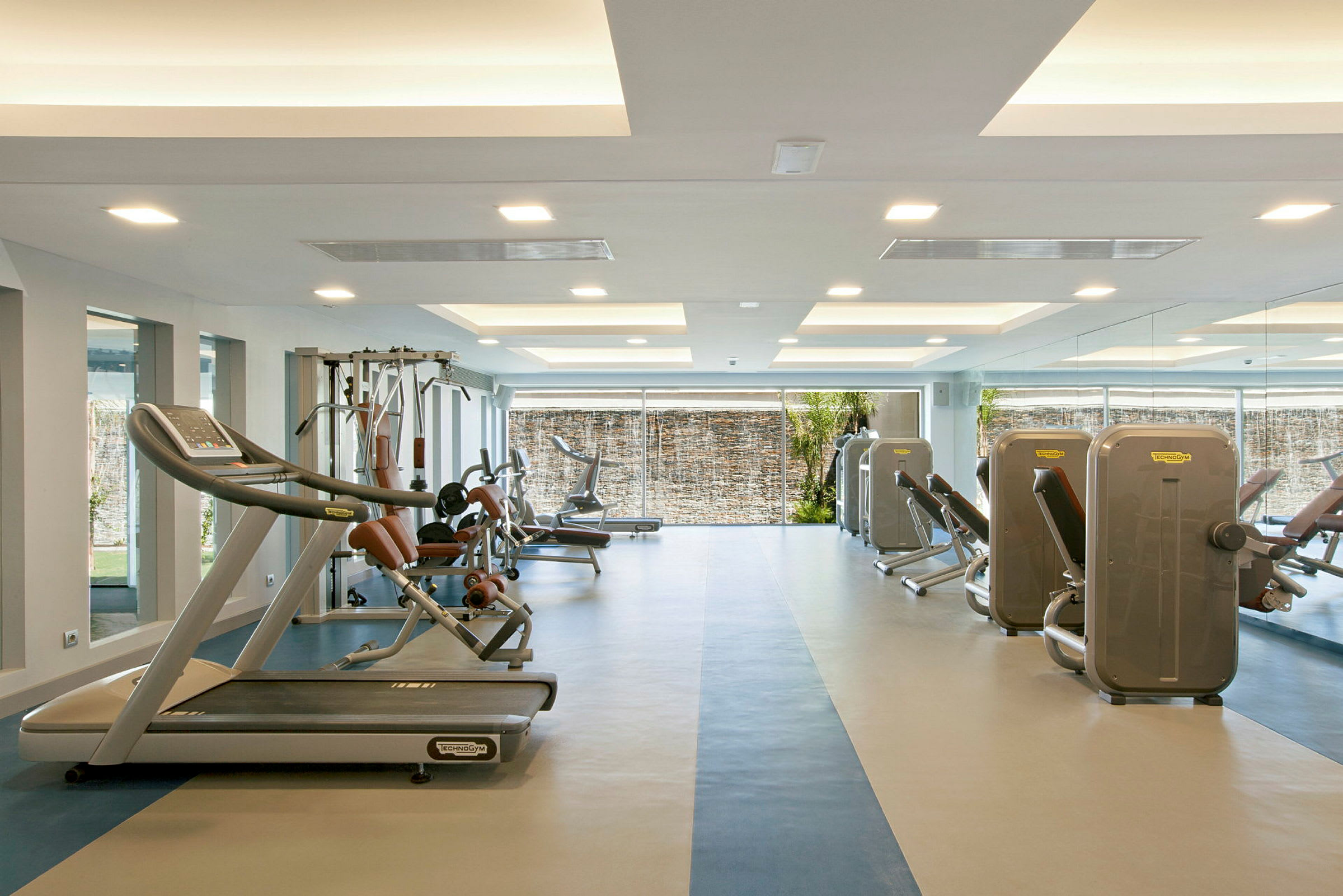 Ett gym med olika träningsmaskiner och ljusa innerytor. (AI-genererad text)