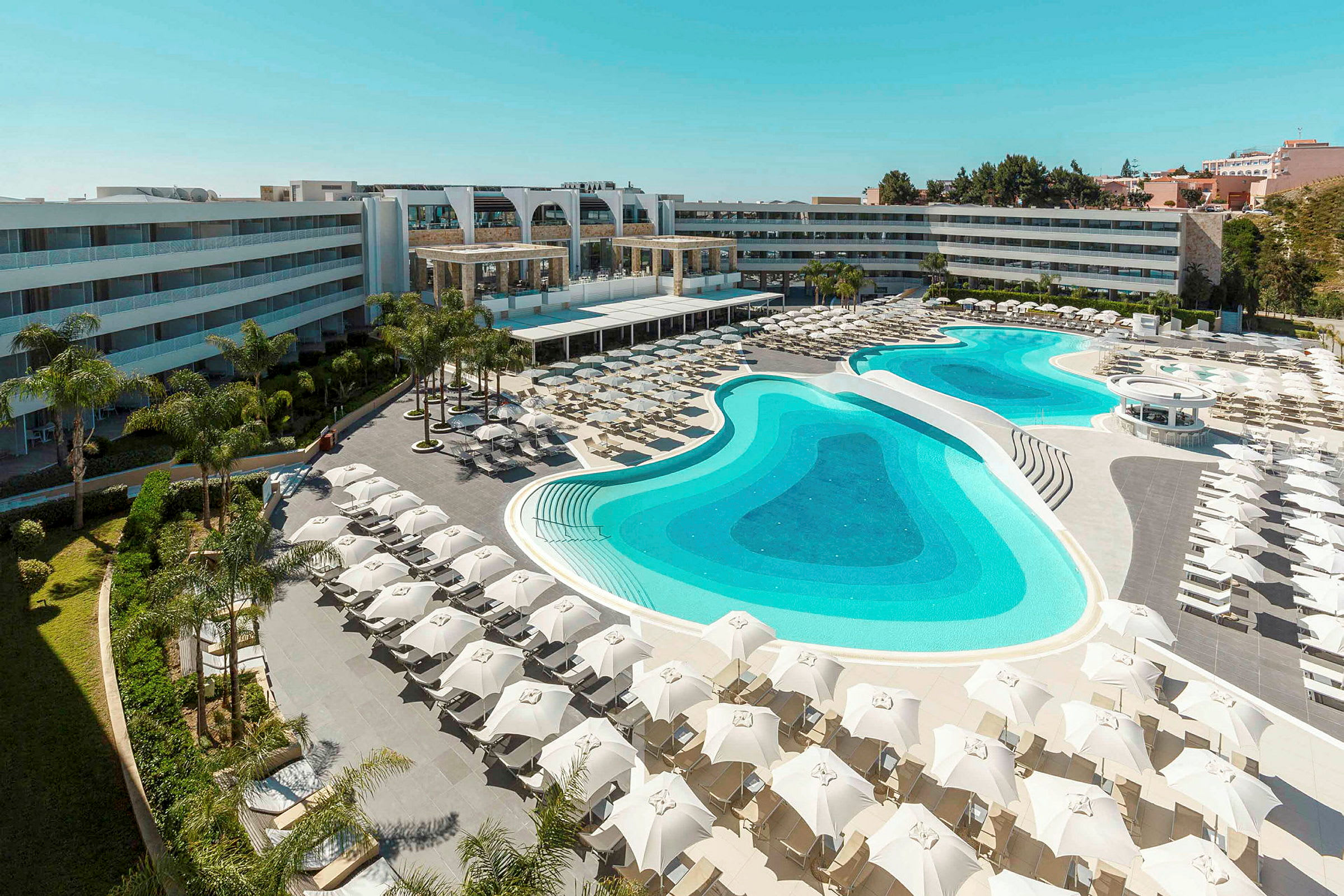 Bild av ett hotellområde med stor pool och solstolar. (AI-genererad text)