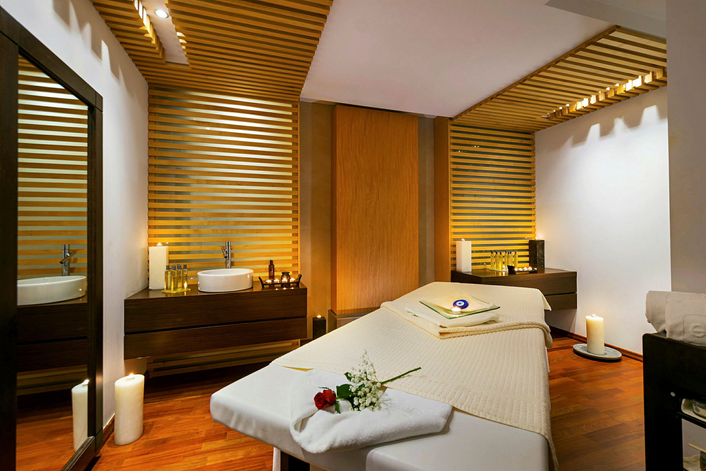 En spa-behandlingsrum med massagebrits, handfat och avslappnande belysning. (AI-genererad text)