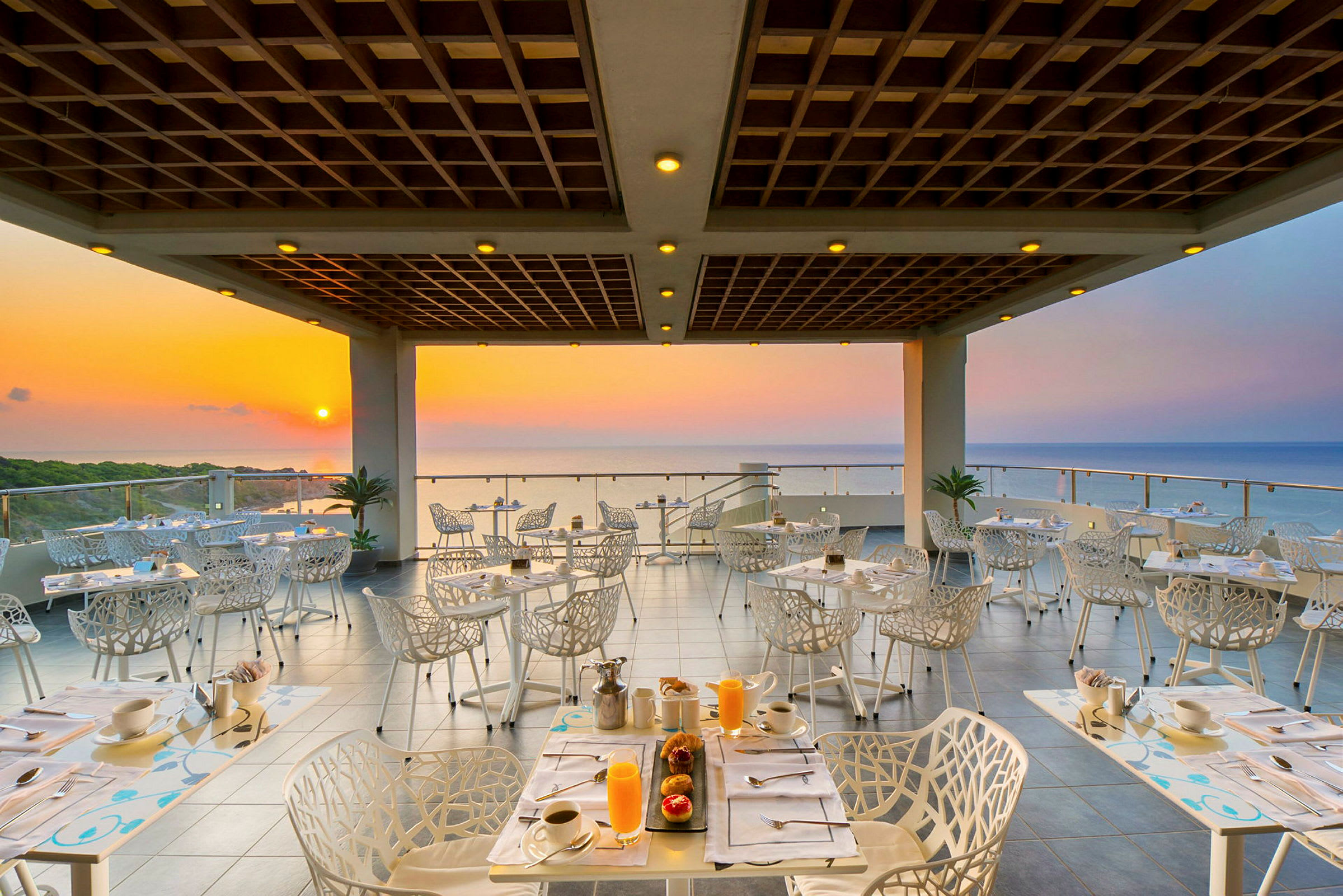 En restaurang med utsikt mot havet vid solnedgången. (AI-genererad text)