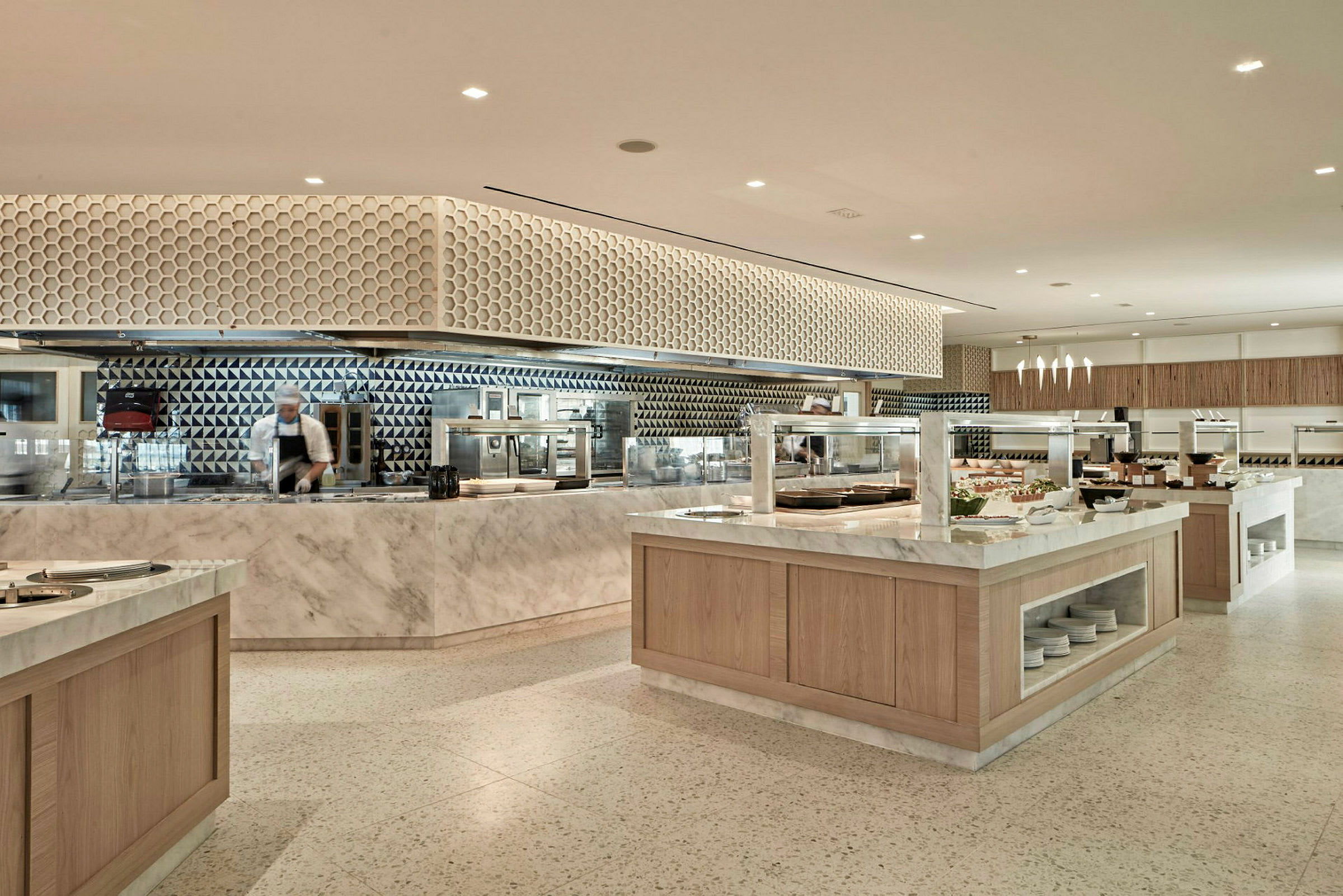 En modern bufférestaurang med marmorbänkar och geometriska väggmönster. (AI-genererad text)