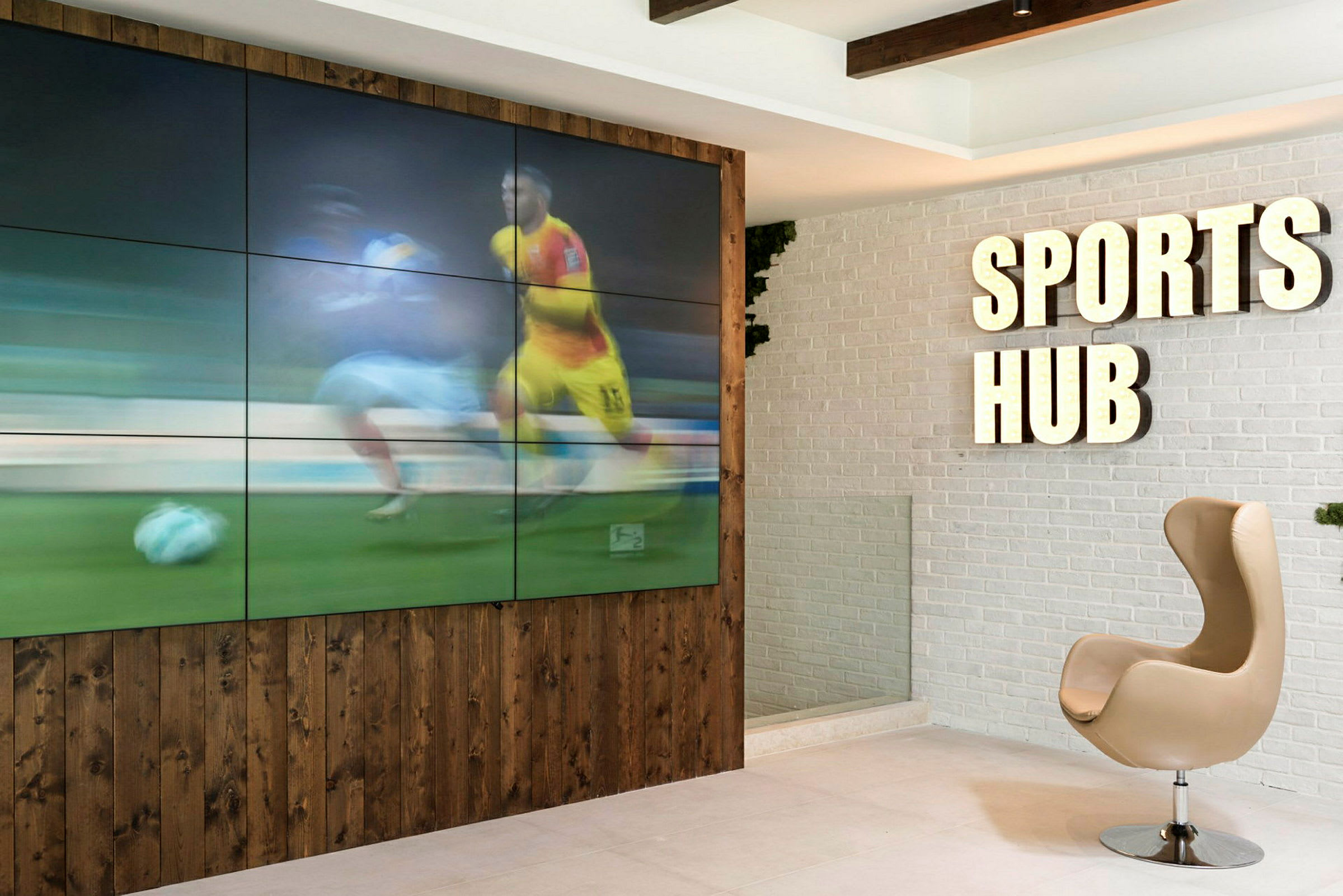 Interiör med skylt som säger 'Sports Hub' och en monitor som visar sport. (AI-genererad text)