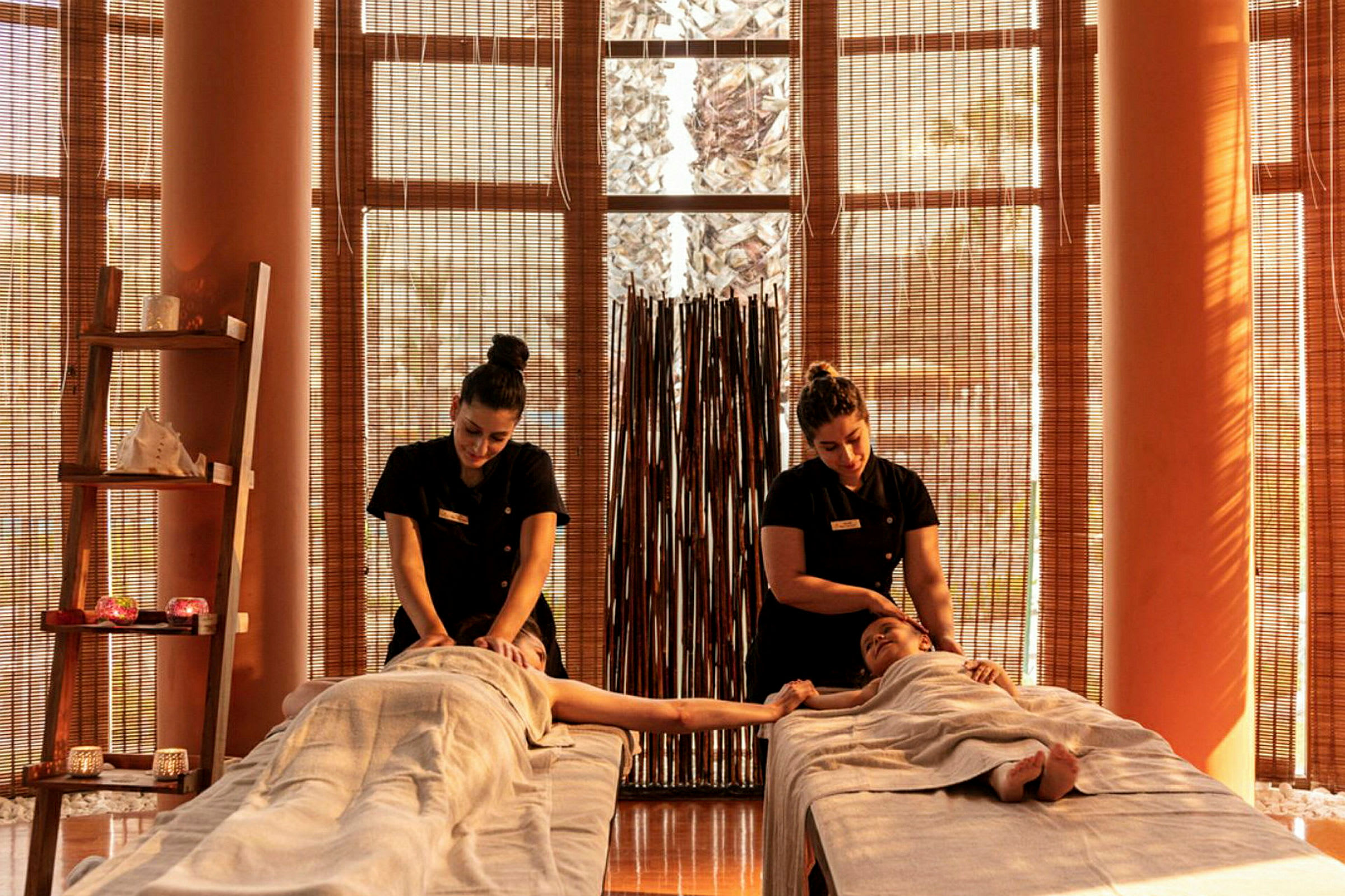 Två personer ligger på massagebänkar i ett spa-rum. (AI-genererad text)
