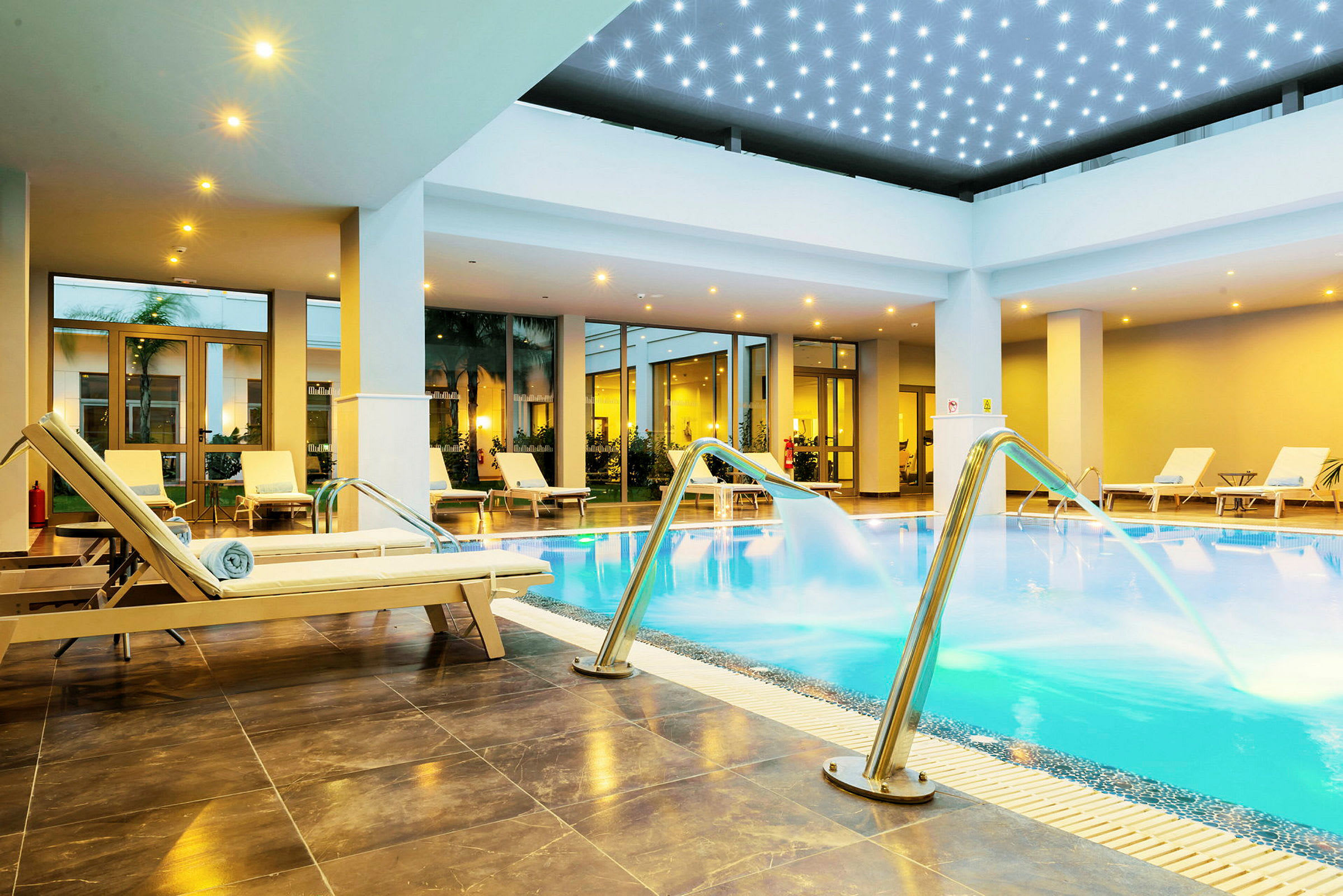 Inomhuspool med solstolar och vattenstrålar. (AI-genererad text)