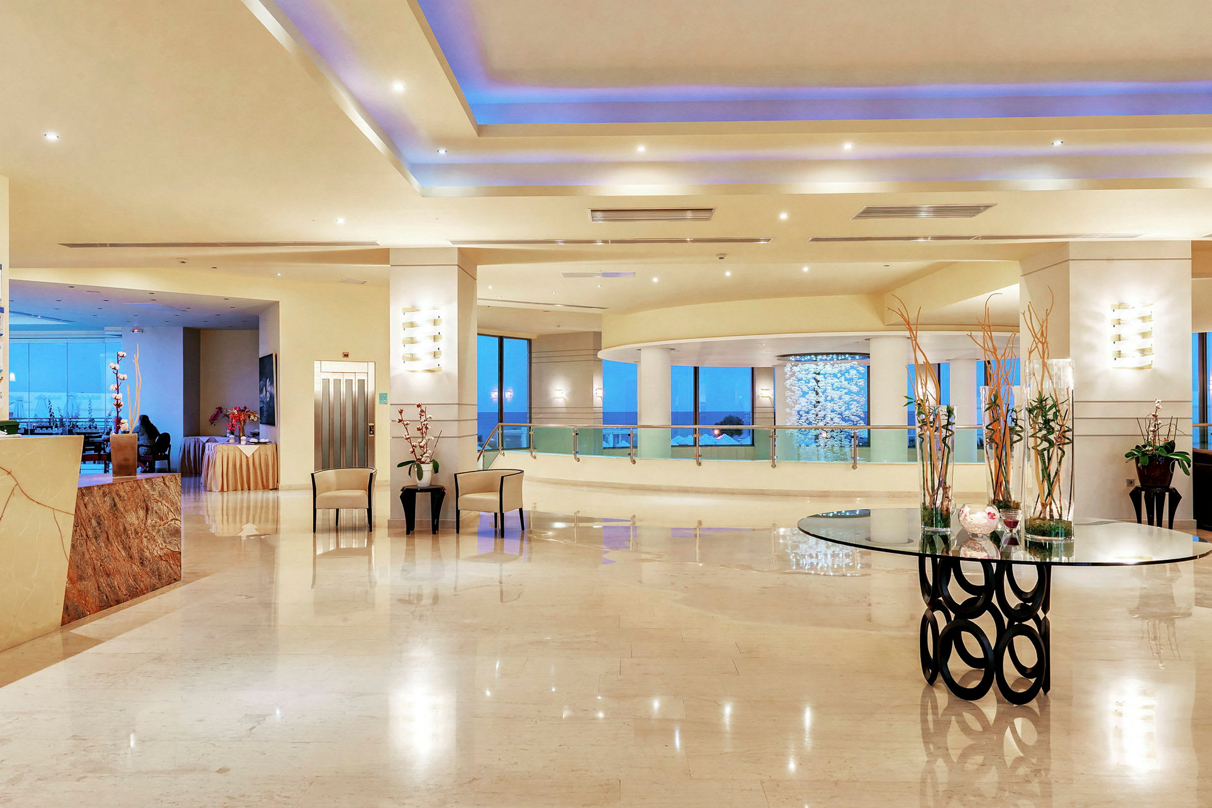 En rymlig hotellreception med modern inredning, glasbord och dekorationer. (AI-genererad text)