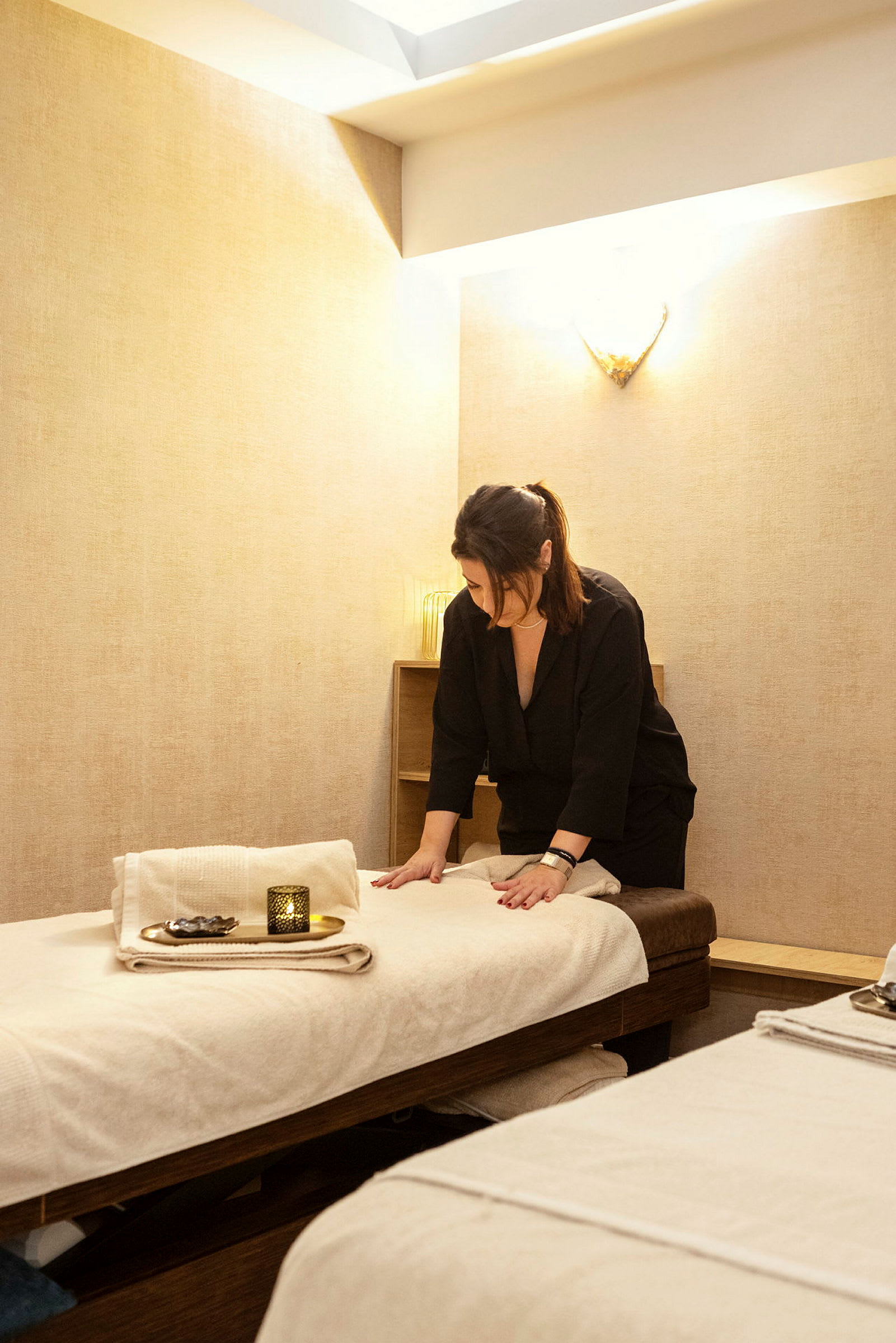 Ett behandlingsrum med en massagebänk, dekorerad med en handduk och ljus. (AI-genererad text)