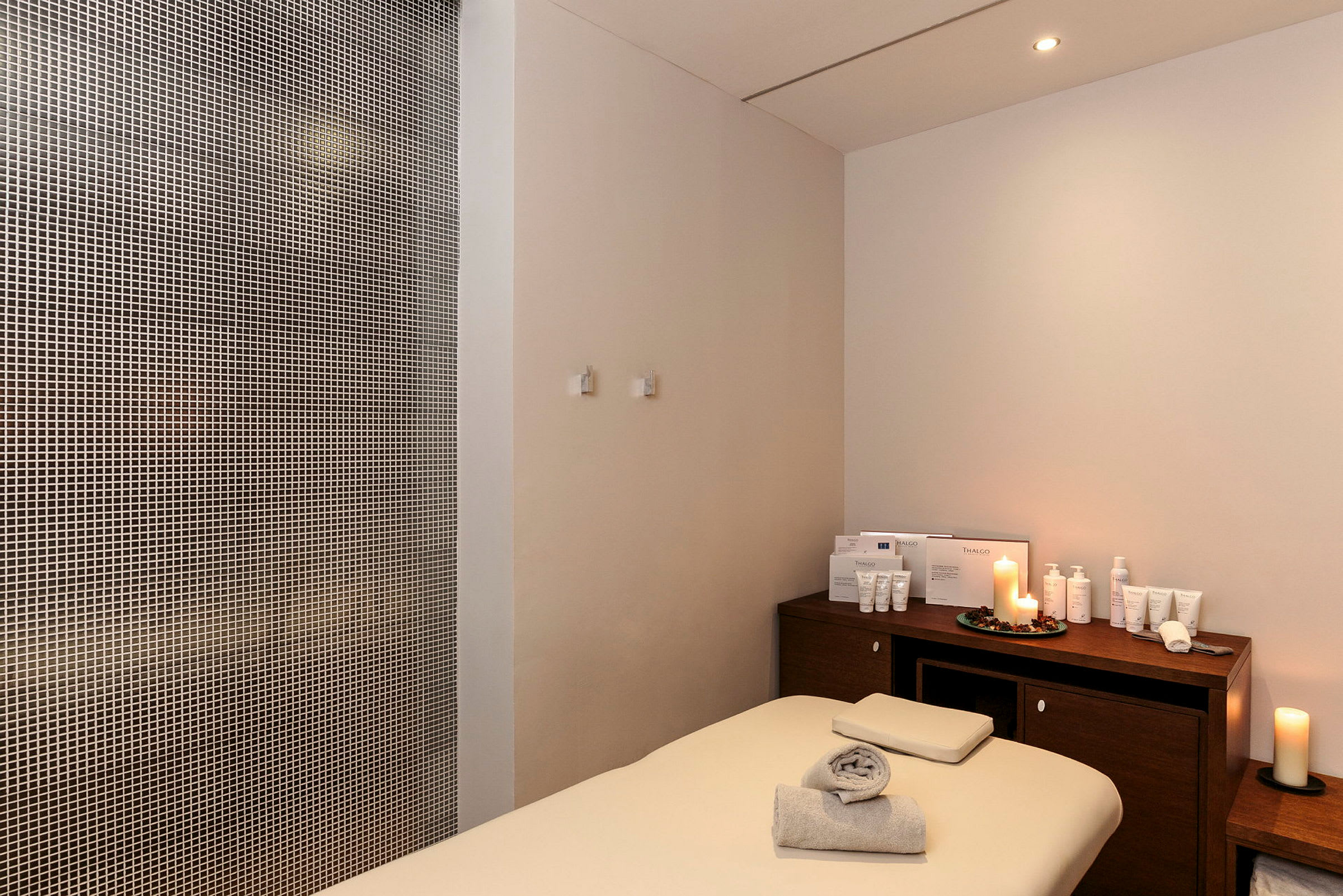 Bild på ett behandlingsrum med en massagebänk och produkter på en träbänk. (AI-genererad text)