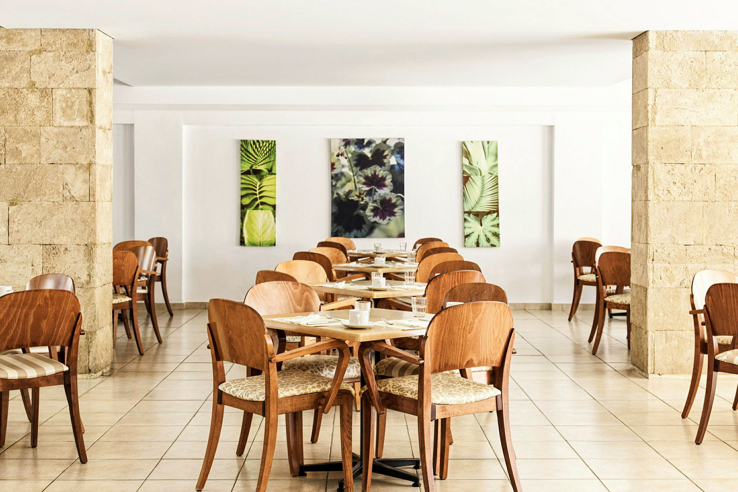 Restaurang med trästolar och bord, dekorerade med konstverk av växtmotiv. (AI-genererad text)