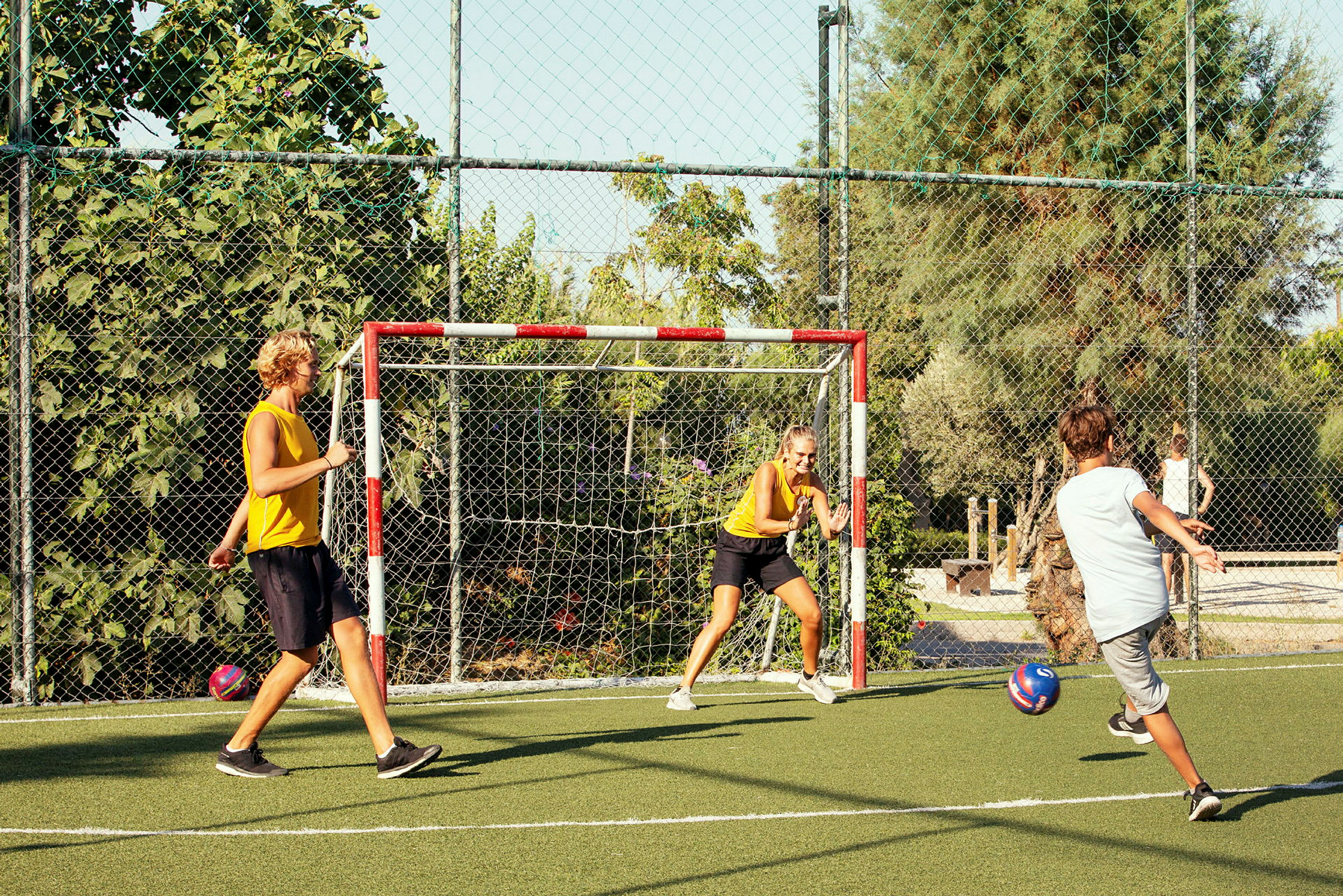 Personer spelar fotboll på en plan utomhus. (AI-genererad text)