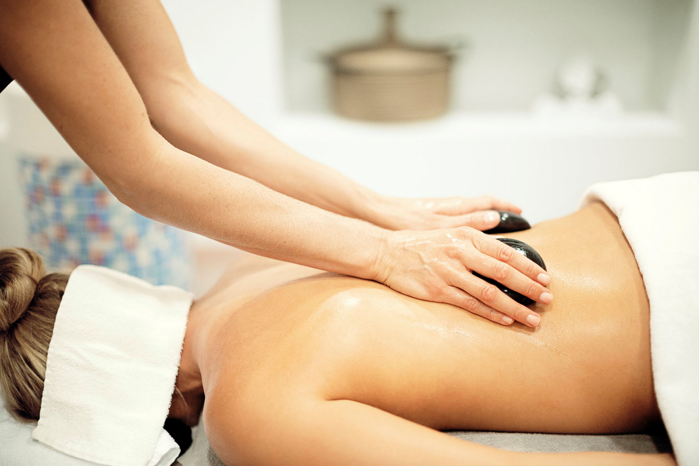 Person får en massage med varma stenar på ryggen. (AI-genererad text)