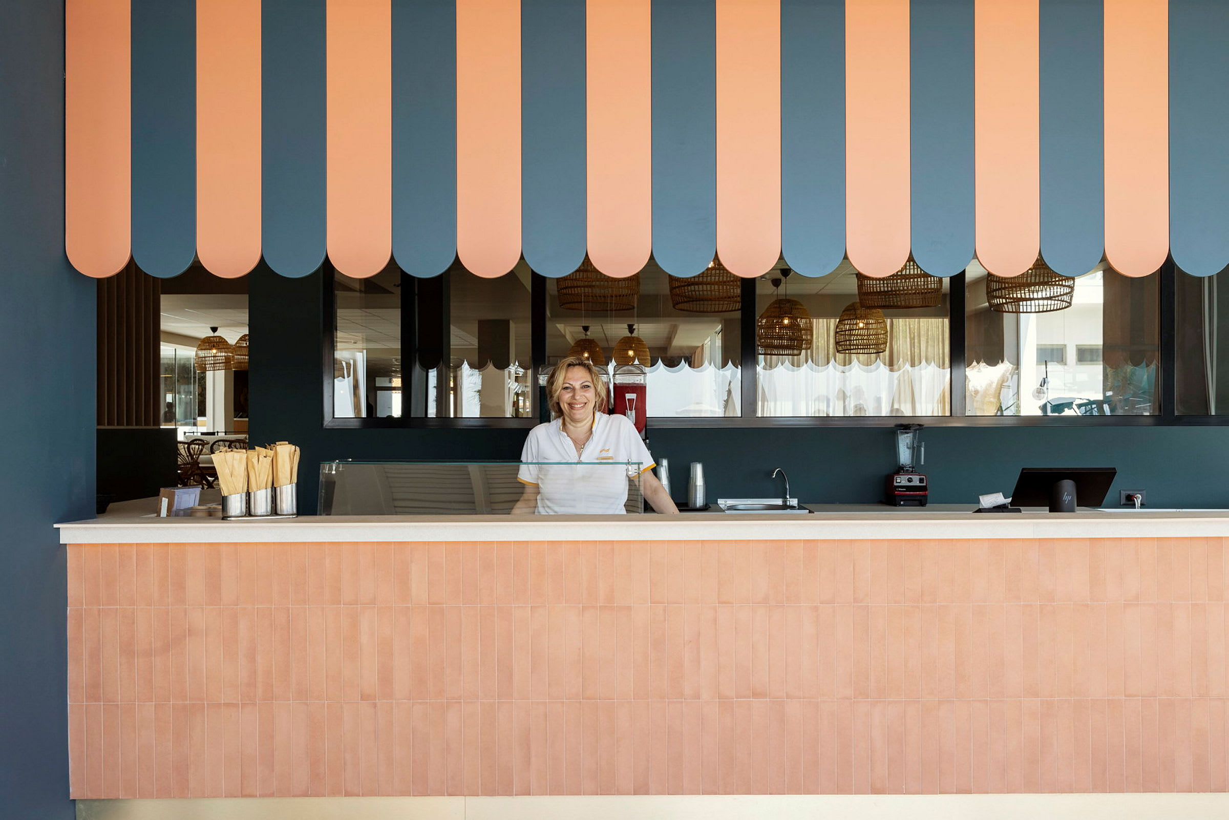 Reception med ett randigt tak i orange och blått samt detaljer i trä. (AI-genererad text)