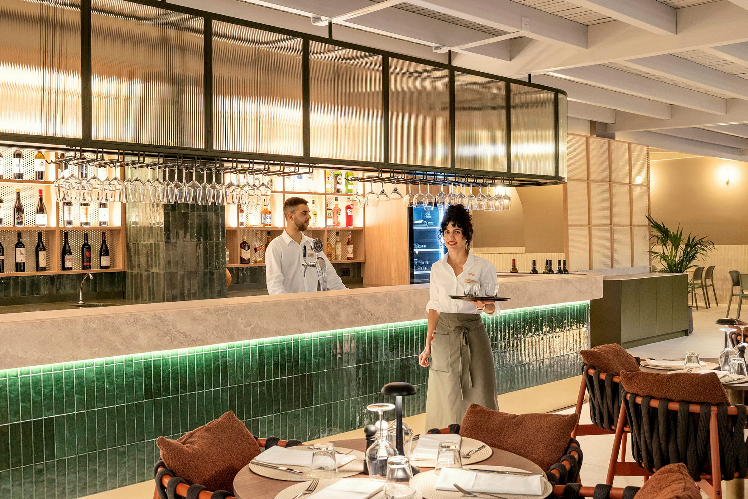 En restauranginteriör med en bardisk och dukade bord. (AI-genererad text)