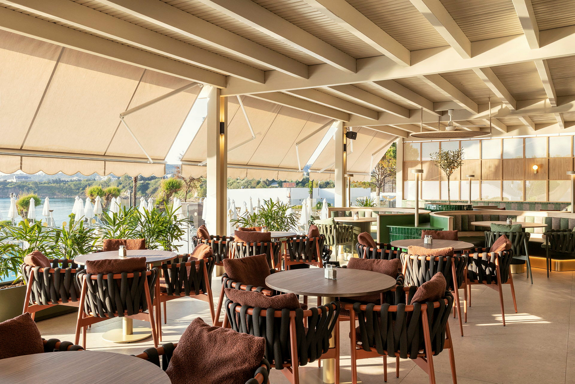 Restaurang med sittplatser vid fönster och utsikt över vatten. (AI-genererad text)