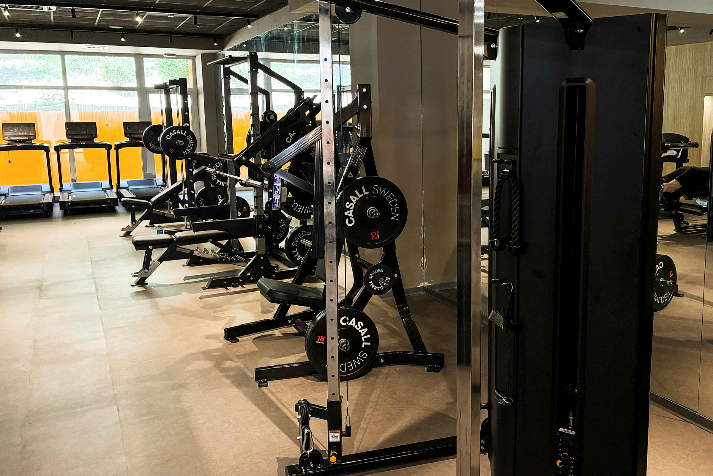 Ett gym med träningsmaskiner, löpband och andra fitnessutrustningar. (AI-genererad text)