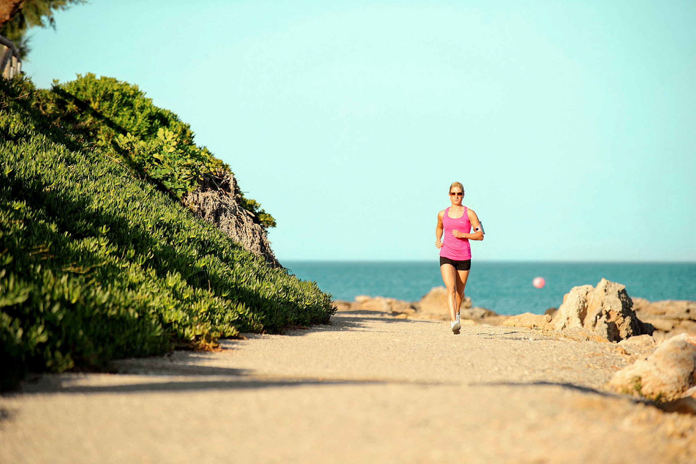 Person som joggar längs en stenig väg vid havet. (AI-genererad text)