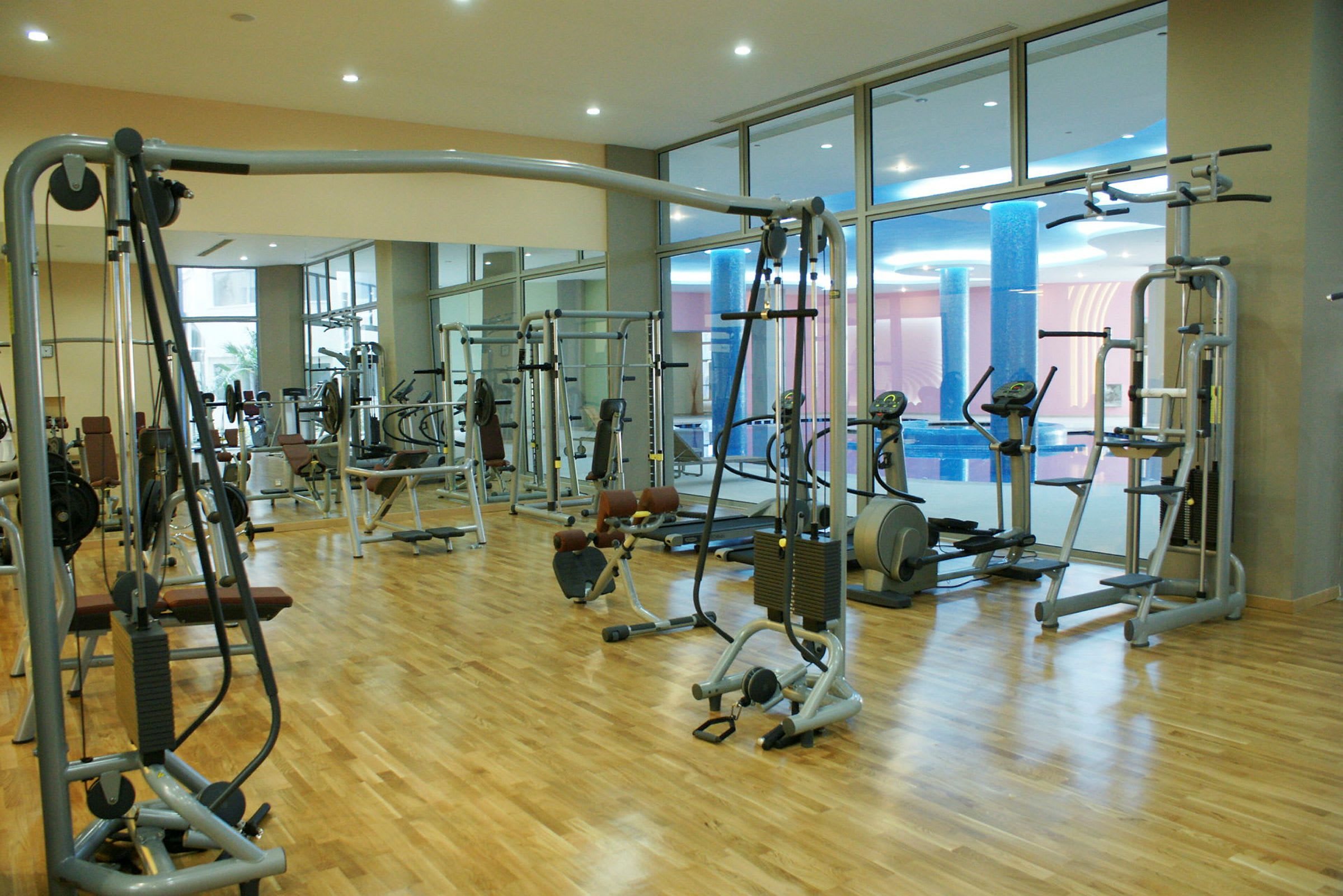 Ett gym med träningsmaskiner placerade på ett trägolv. (AI-genererad text)
