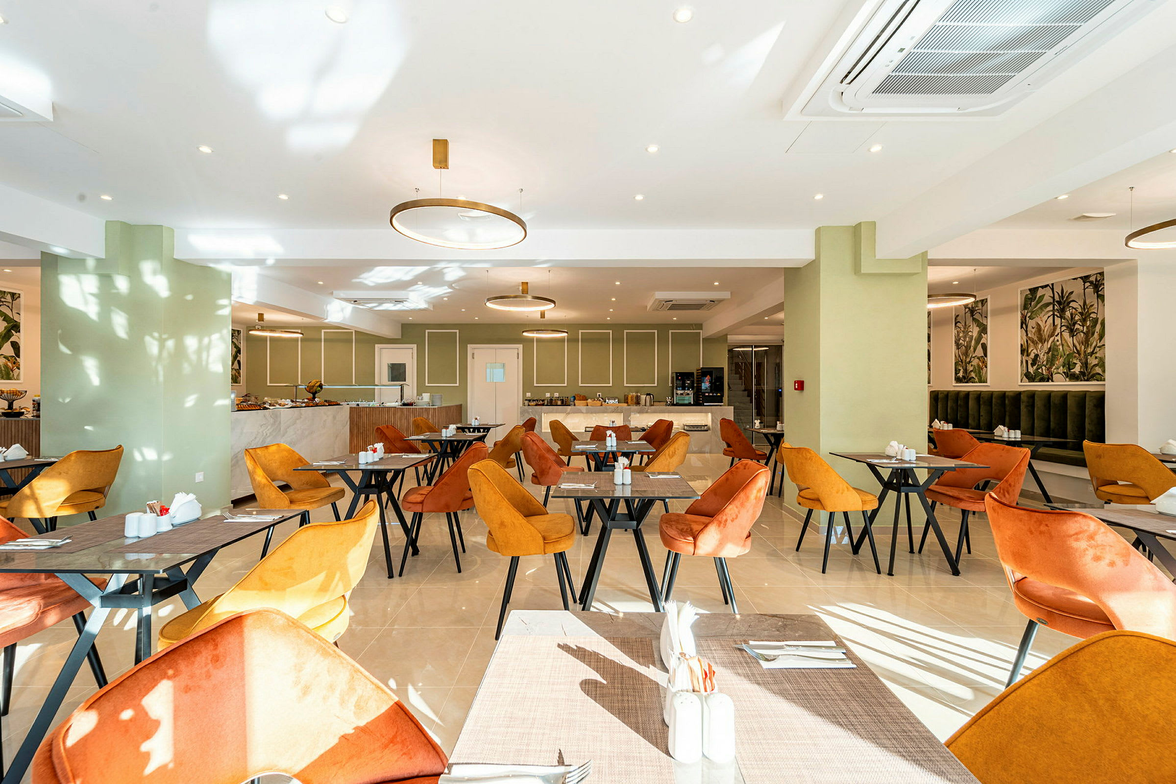 En ljus restaurang med orange och gula stolar samt bord. (AI-genererad text)