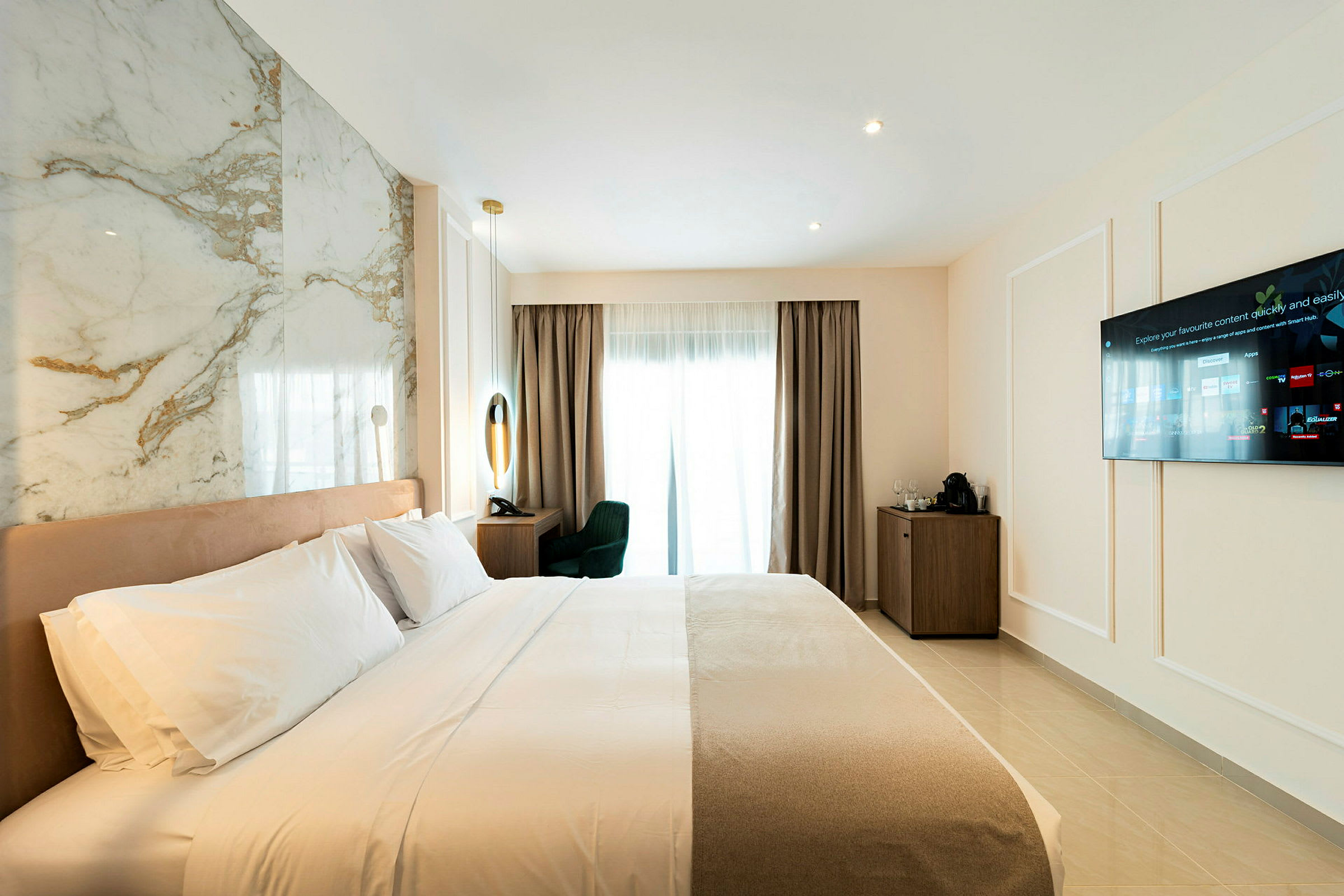Hotellrum med bäddad säng, vägg-TV och skrivbord nära ett fönster. (AI-genererad text)