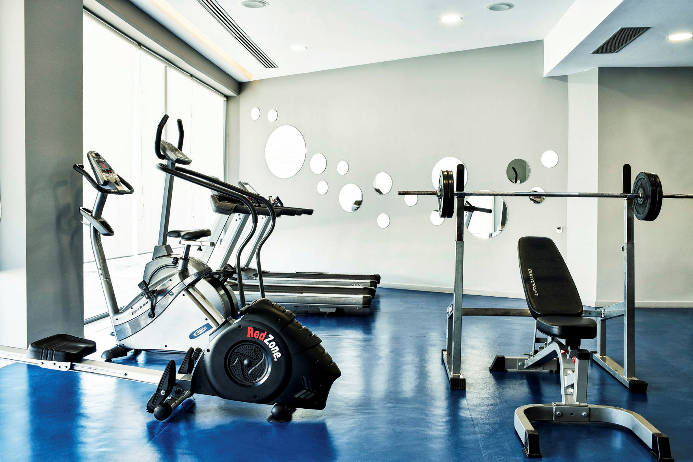 Gym med träningsmaskiner som löpband och styrketräningsutrustning. (AI-genererad text)