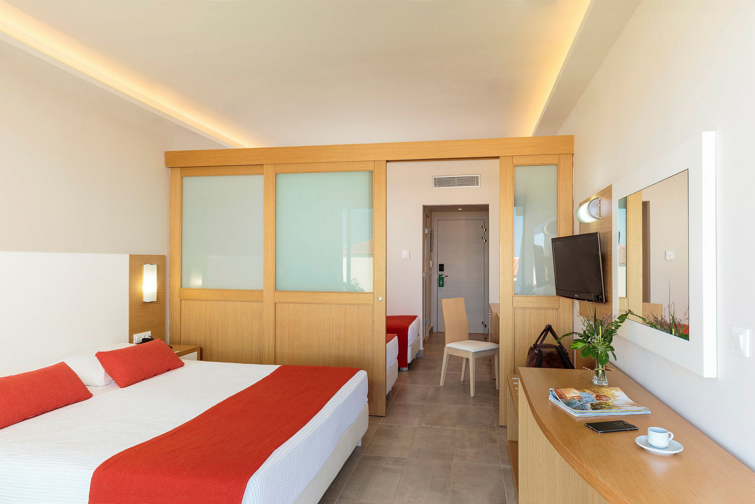 Hotellrum med dubbelsäng och röda dekorativa inslag. (AI-genererad text)