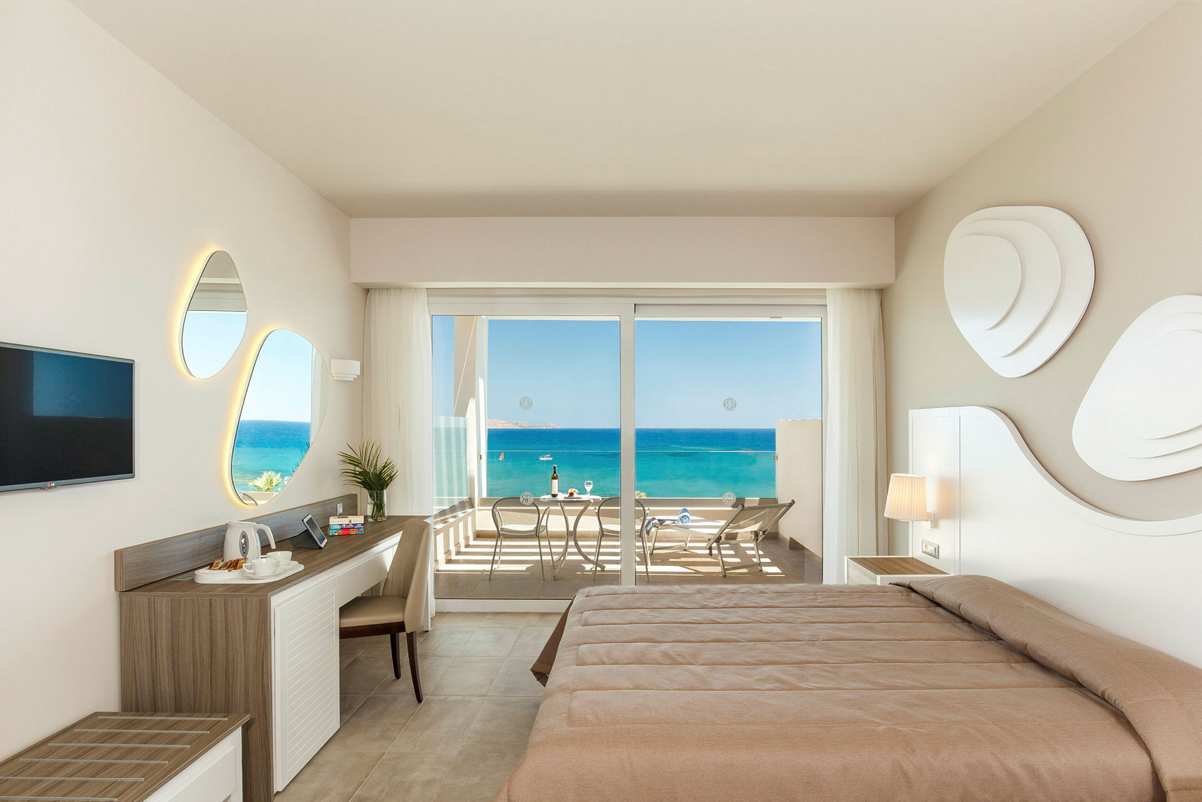 Hotellrum med utsikt över havet från en balkong. (AI-genererad text)