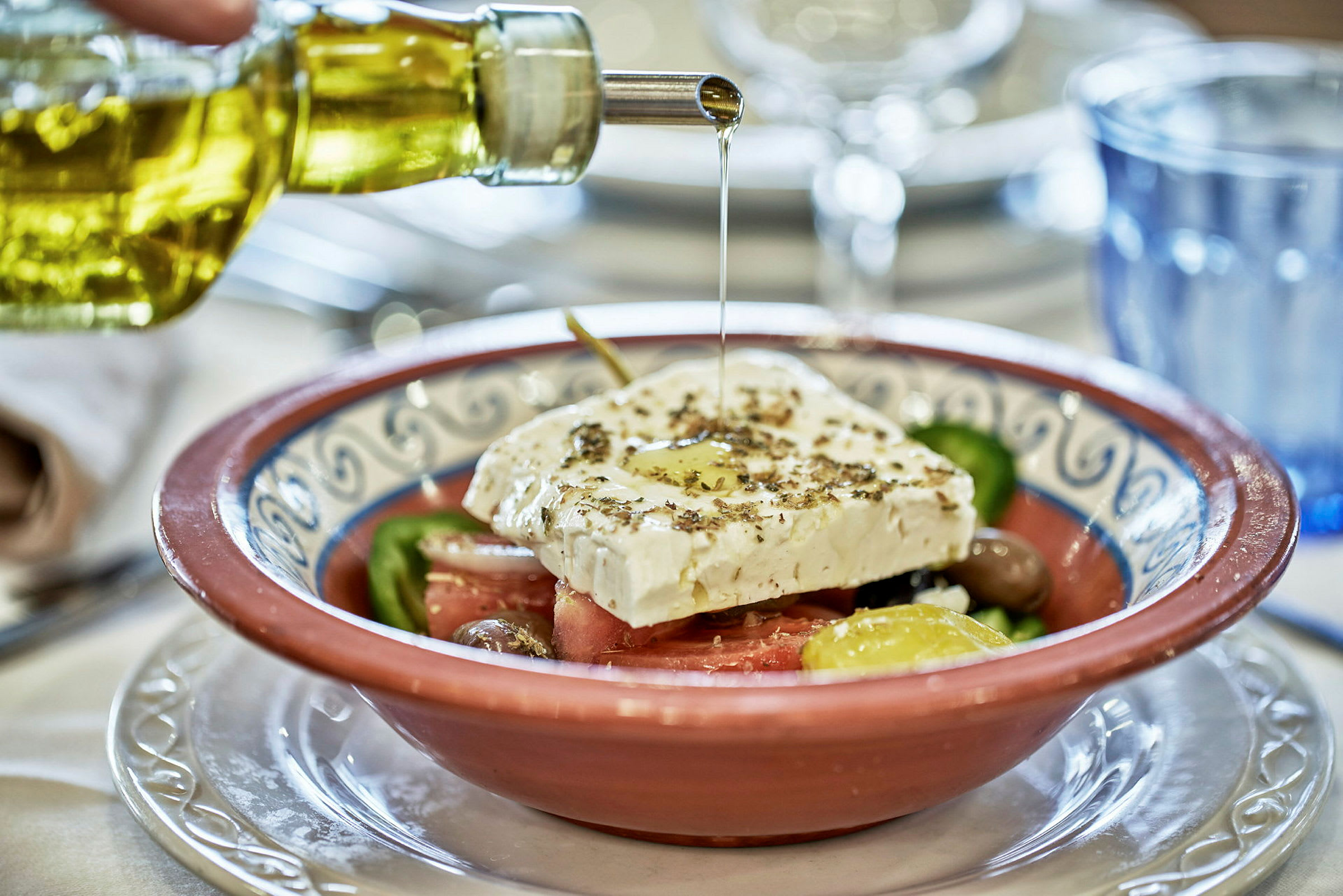 En skål med grekisk sallad, toppad med fetaost och olivolja. (AI-genererad text)