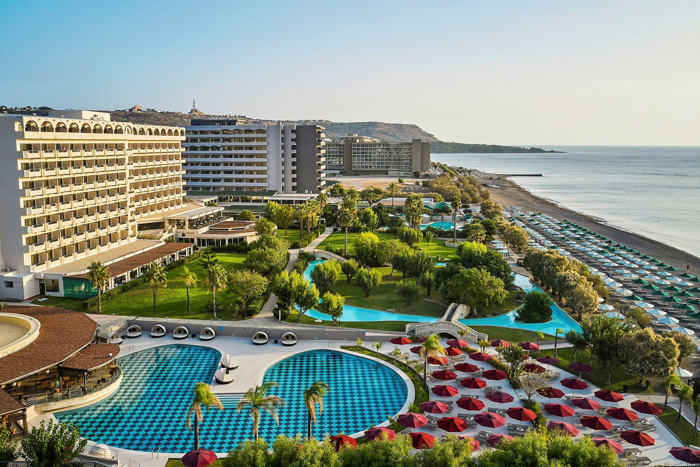 Hotellanläggning med pooler, grönområden och strand. (AI-genererad text)